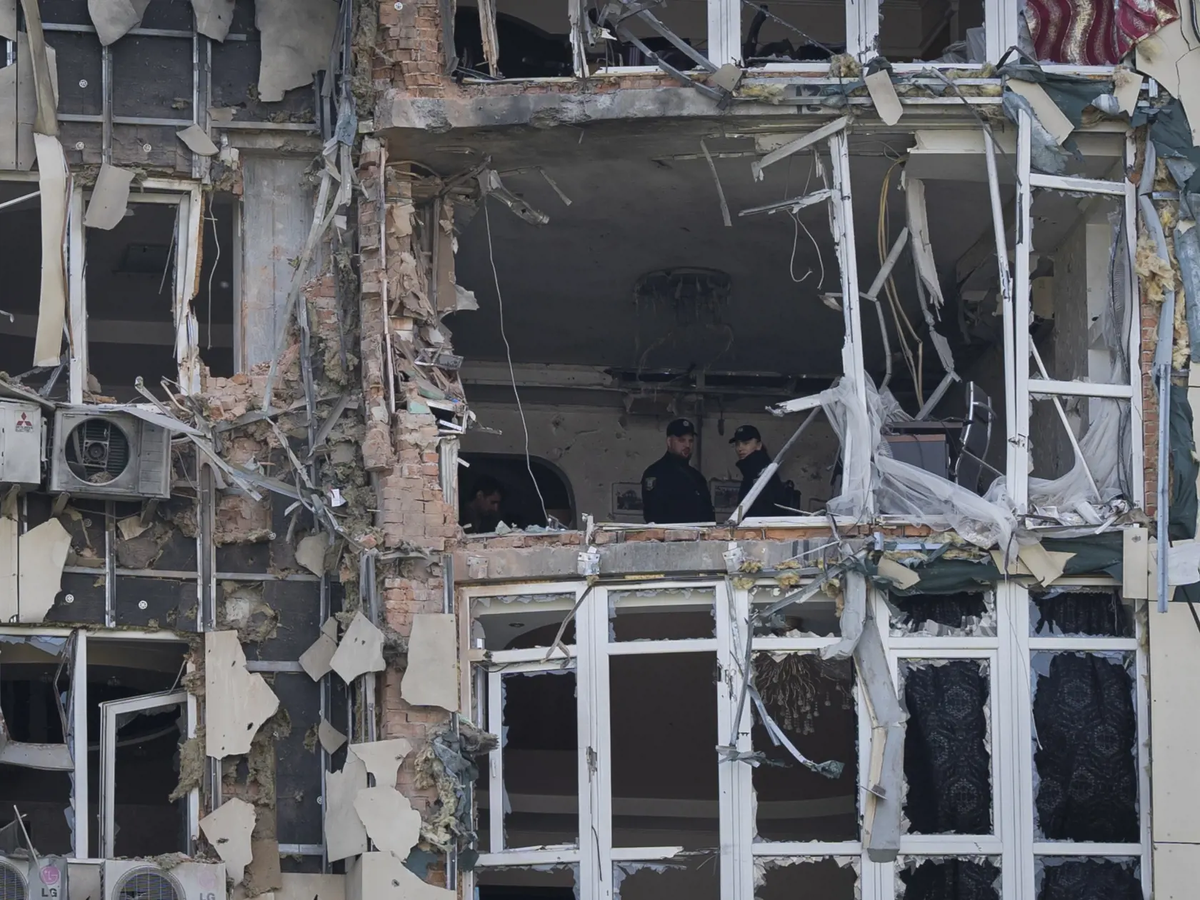 Policajti skúmajú obytnú budovu zničenú dronom, na ktorú dopadol počas ruského nočného útoku v Kyjeve 8. mája 2023.