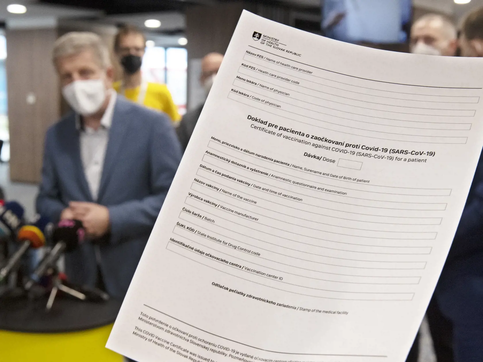 Na snímke vľavo minister zdravotníctva SR Vladimír Lengvarský a v popredí doklad pre pacienta o zaočkovaní proti Covid-19 predstavený na brífingu vo veľkokapacitnom vakcinačnom centre v priestoroch Národného futbalového štadióna 20. mája 2021 v Bratislave. FOTO TASR - Pavel Neubauer