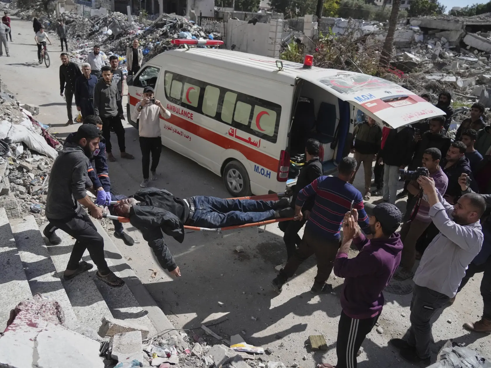 Palestínčania evakuujú zraneného muža po tom, ako jeho dom zasiahlo izraelské bombardovanie v Gaze v stredu 19. marca 2025.  Izraelská armáda v stredu oznámila, že v severnej časti Pásma Gazy spúšťa "obmedzenú pozemnú operáciu", ktorej cieľom je podľa nej znovu dobyť časť koridoru Necarim. Minister obrany Jisrael Kac predtým Palestínčanov upozornil, že Izrael čoskoro opäť nariadi evakuácie z bojových zón v pobrežnej enkláve.