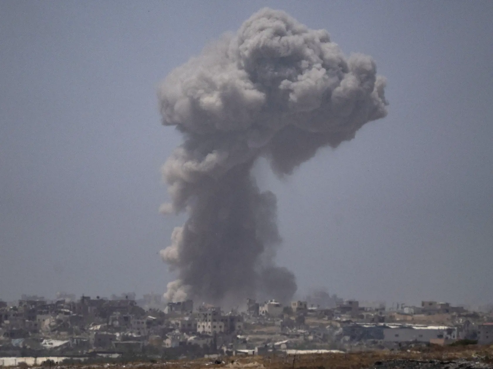Dym stúpa pri explózii po izraelskom bombardovaní pásma Gazy, čo je viditeľné z juhu Izraela v utorok 21. mája 2024. Izraelská armáda bojuje s palestínskymi militantmi hnutia Hamas v pásme Gazy po útokoch Hamasu na Izrael 8. októbra.