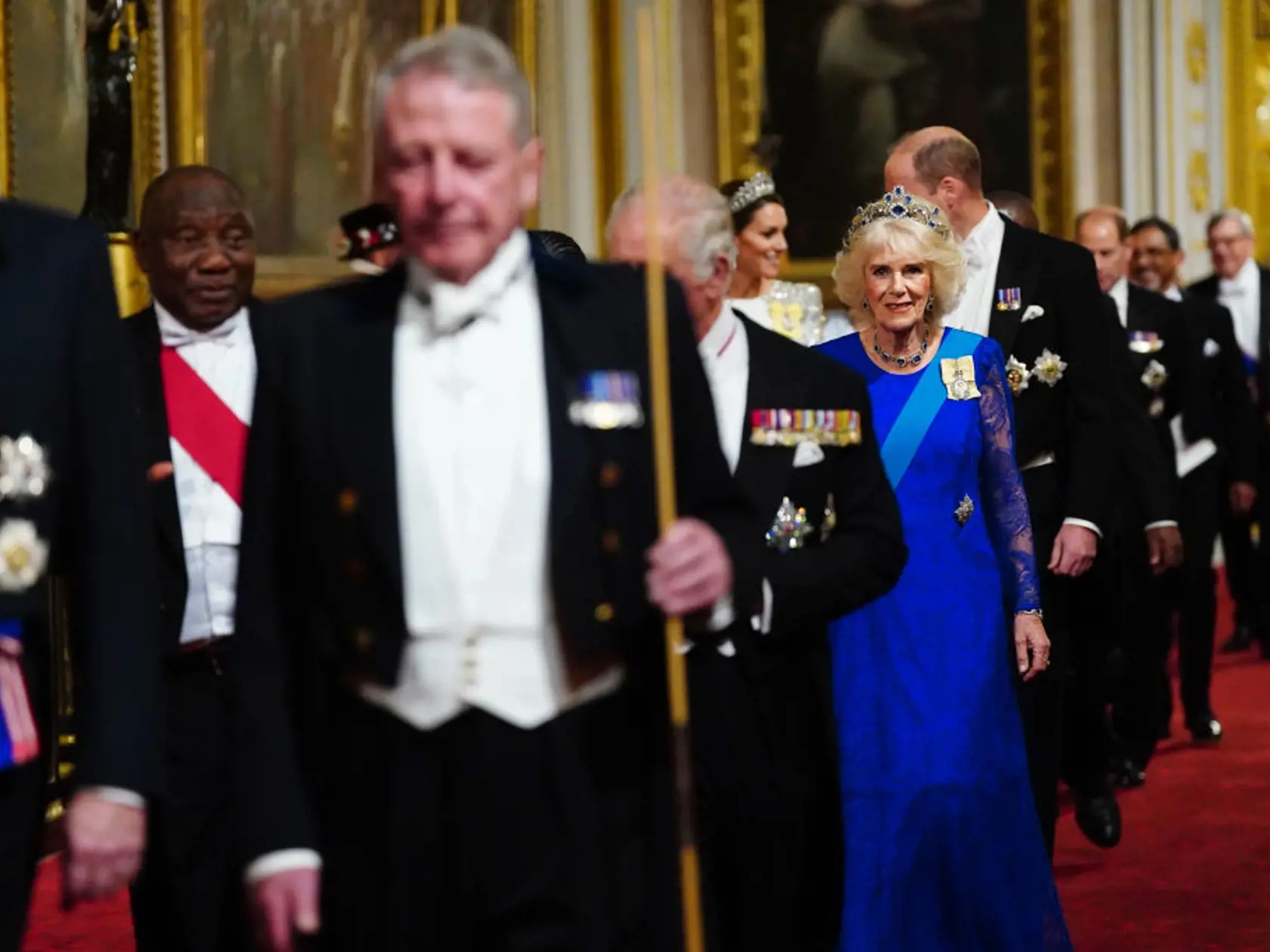 Zatieniť sa nedala ani kráľovná manželka Camilla. Tá si na významnú príležitosť obliekla elegantné modré šaty z dielne Bruce Oldfield Couture, na ktorých mala pripnutú rovnakú brošňu s podobizňou kráľovnej Alžbety, akú mala aj Kate. A zatiaľ, čo princezná zvolila tiaru princeznej Diany, kráľovná manželka si na hlavu nasadila zafírový diadém zosnulej kráľovnej Alžbety II.