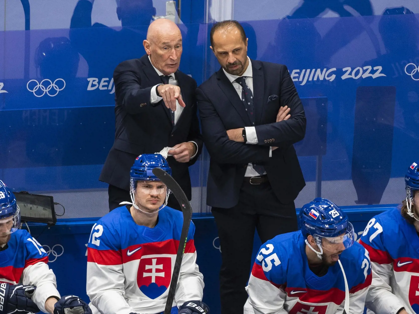 Na snímke zľava hráči Slovenska Michal Krištof, Miloš Kelemen, hore tréner slovenskej hokejovej reprezentácie Craig Ramsay a asistent trénera Ján Pardavý a hráči Slovenska Peter Zuzin a Pavol Regenda vo štvrťfinále olympijského turnaja v hokeji mužov USA - Slovensko na ZOH 2022 v Pekingu v stredu 16. februára 2022. FOTO TASR - Jaroslav Novák