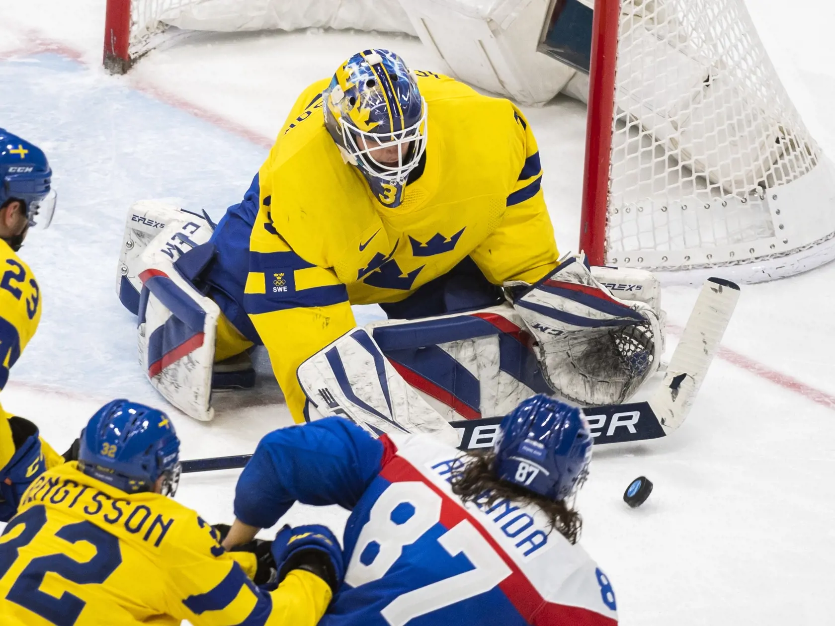 Na snímke zľava hráči Švédska Lucas Wallmark, Lukas Bengtsson, hokejista Slovenska Pavol Regenda a hore brankár Švédska Lars Johansson v zápase olympijského turnaja v hokeji mužov o bronz Slovensko - Švédsko na ZOH 2022 v Pekingu v sobotu 19. februára 2022. FOTO TASR - Jaroslav Novák