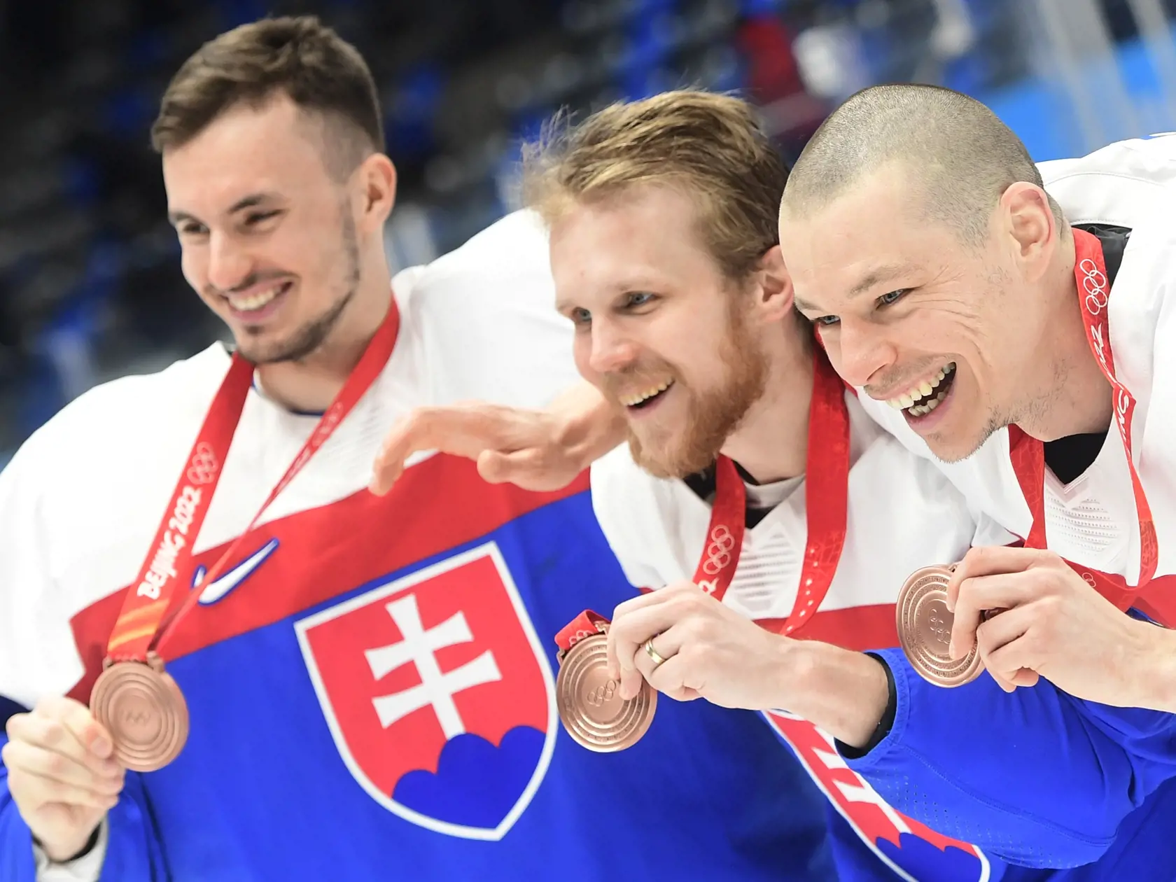 Na snímke slovenskí hráči sprava Marek Ďaloga, Michal Krištof a Matej Tomek oslavujú po zisku bronzu po zápase olympijského turnaja v hokeji mužov o bronz Slovensko - Švédsko na ZOH 2022 v Pekingu v sobotu 19. februára 2022. FOTO TASR - Martin Baumann
