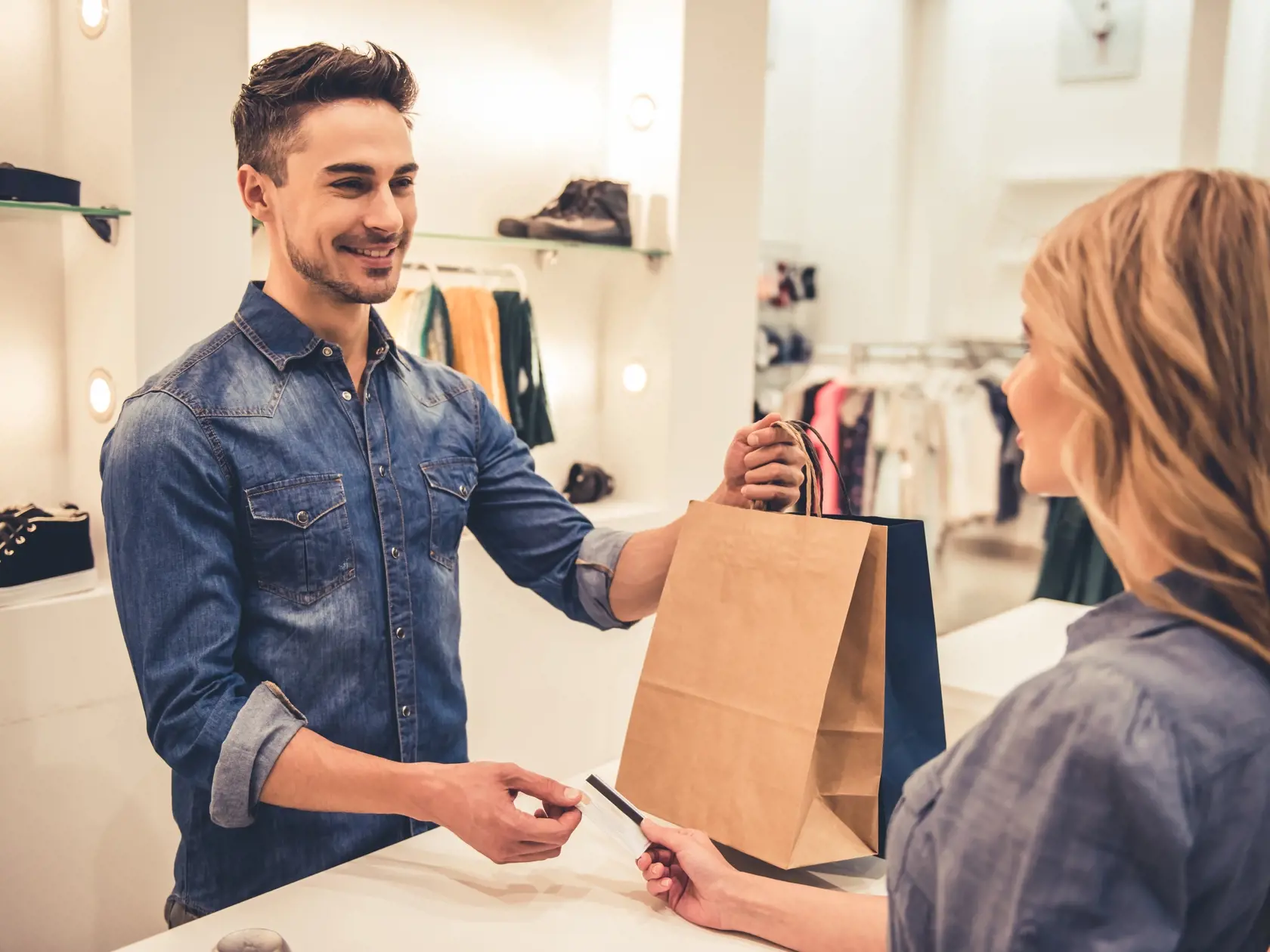 Handsome,Shop,Assistant,Is,Smiling,While,Giving,Purchases,And,Credit