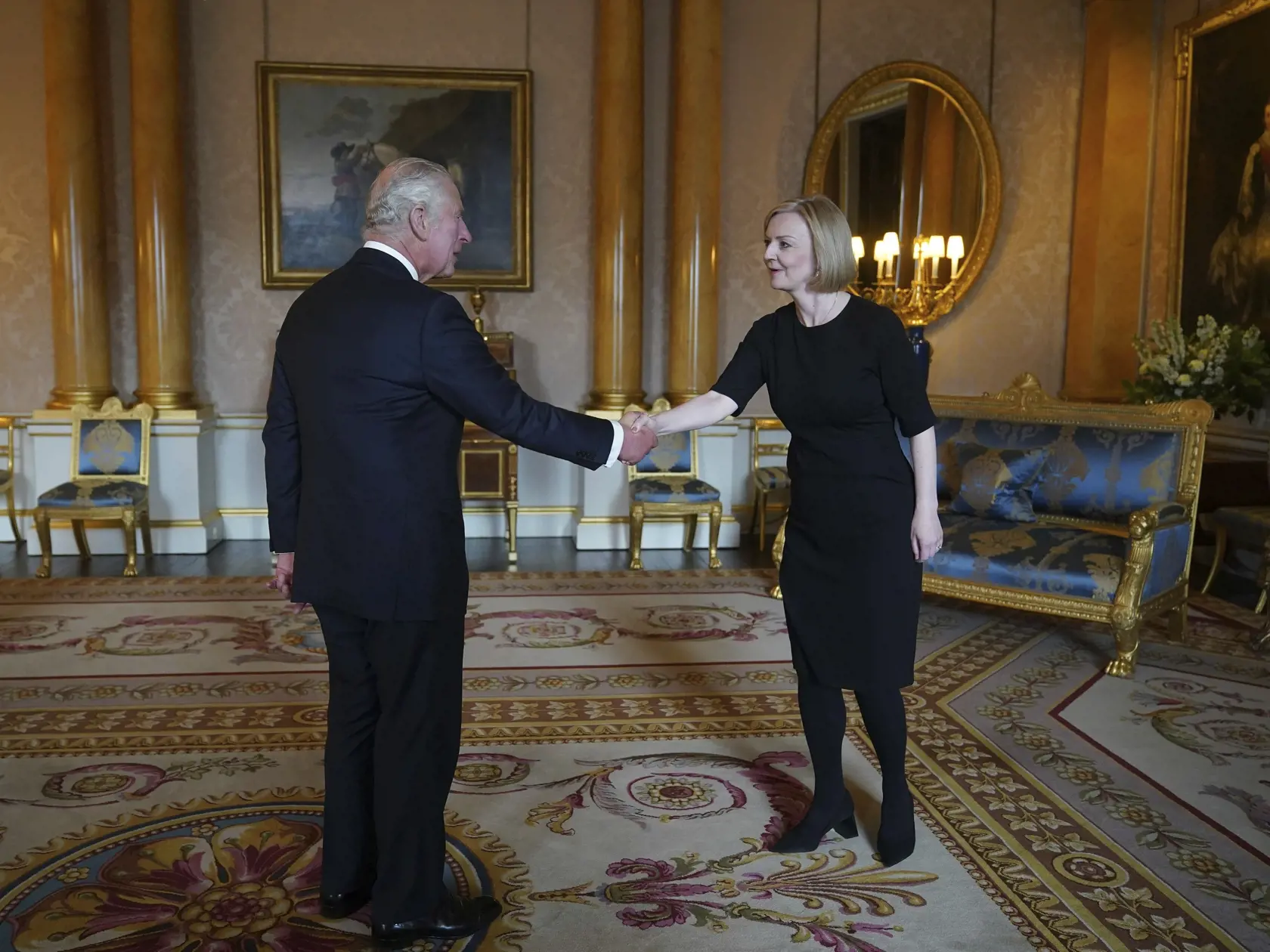 Na snímke zľava nový britský kráľ Charles III. a britská premiérka Liz Trussová si podávajú ruky počas audiencie v Buckinghamskom paláci v Londýne 9. septembra 2022.