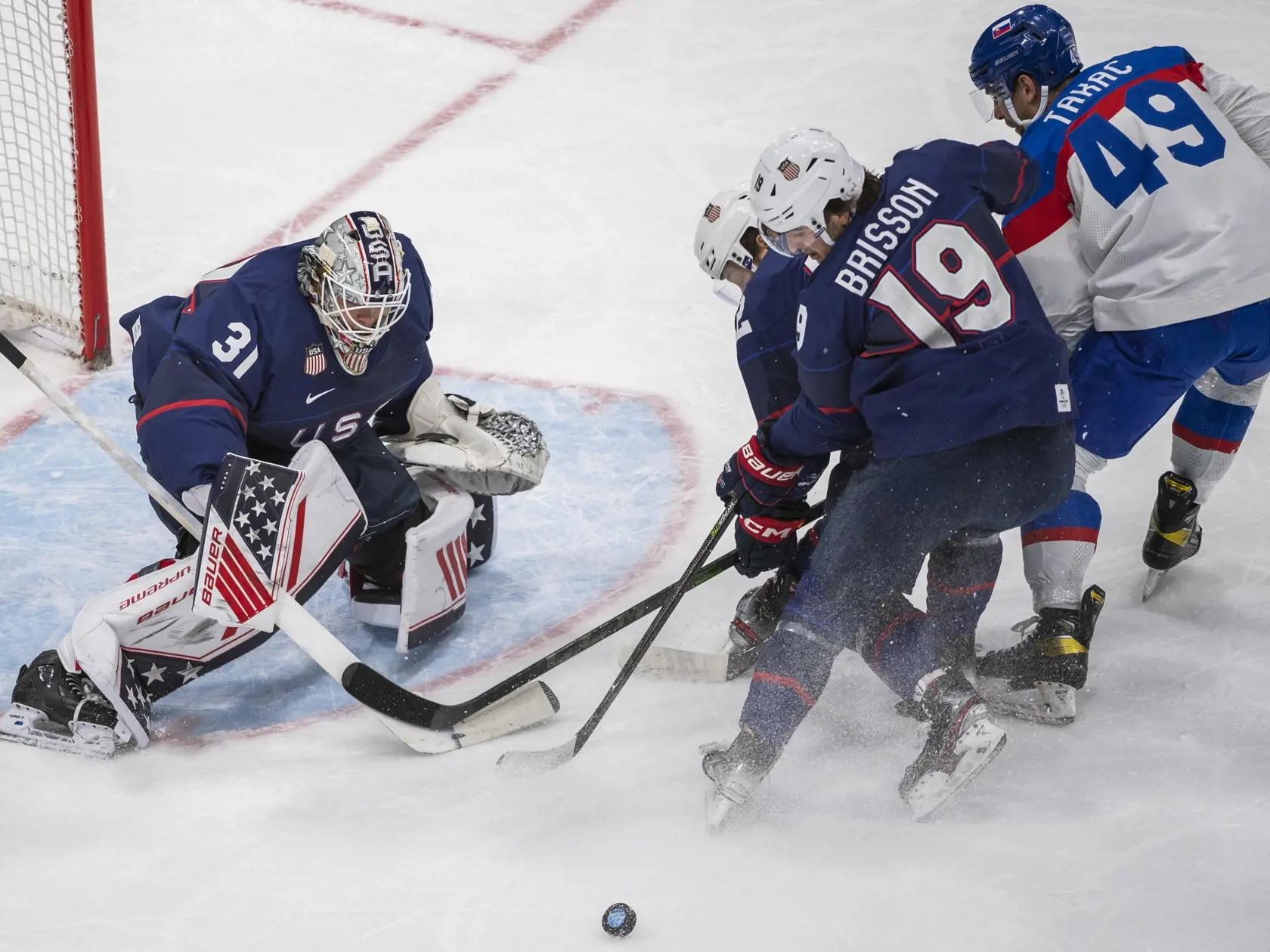 Na snímke zľava hráči  USA Strauss Mann, Aaron Ness, Brendan Brisson a hráč Slovenska Samuel Takáč vo štvrťfinále olympijského turnaja v hokeji mužov USA - Slovensko na ZOH 2022 v Pekingu v stredu 16. februára 2022. FOTO TASR - Jaroslav Novák