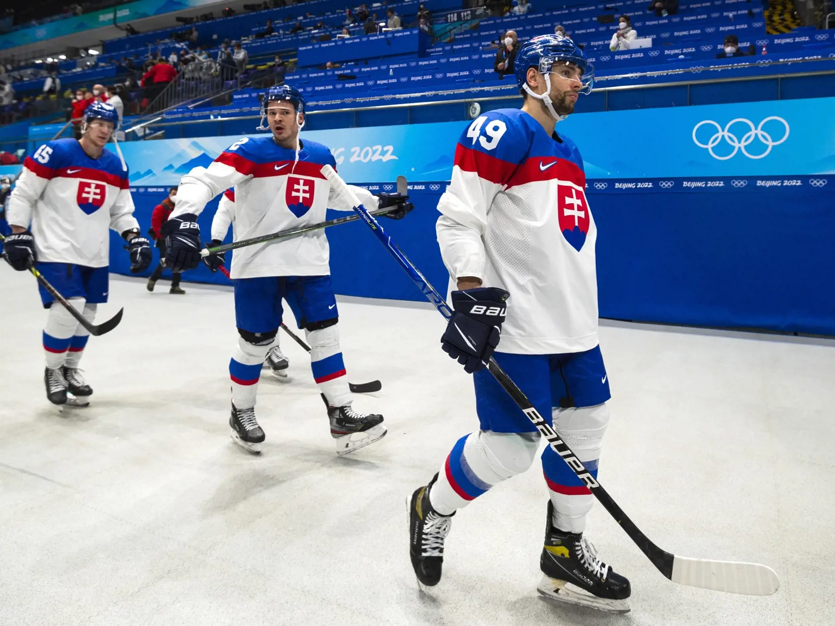 Na snímke hokejisti Slovenska, zľava Michal Čajkovský, Miloš Kelemen a Samuel Takáč odchádzajú po prehre 0:2 v semifinále olympijského turnaja v hokeji mužov Fínsko - Slovensko na ZOH 2022 v Pekingu v piatok 18. februára 2022. FOTO TASR - Jaroslav Novák