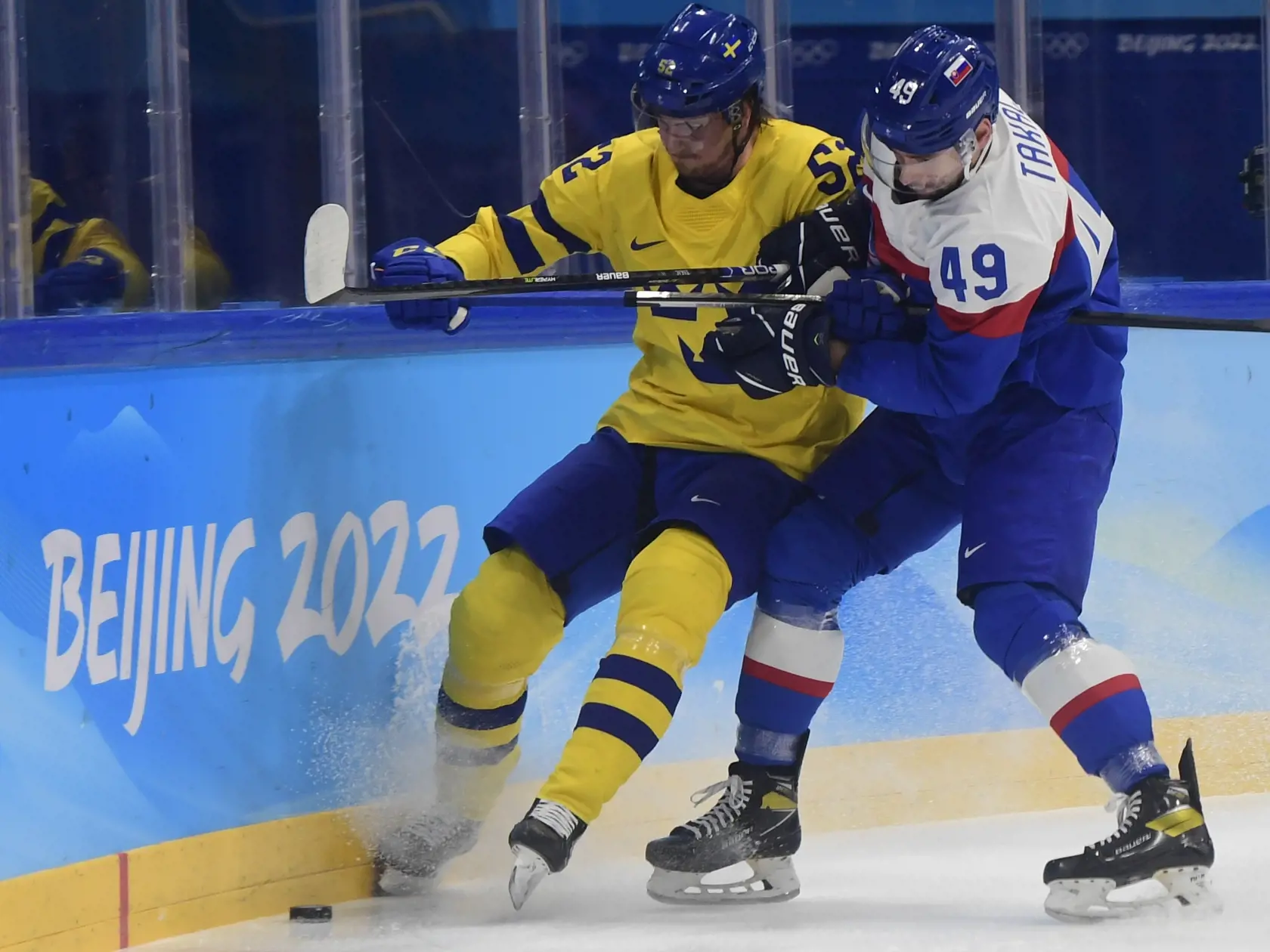Na snímke sprava Samuel Takáč (Slovensko) a  Philip Holm (Švédsko) počas olympijského turnaja v hokeji mužov o bronz Slovensko - Švédsko na ZOH 2022 v Pekingu v sobotu 19. februára 2022. FOTO TASR - Martin Baumann