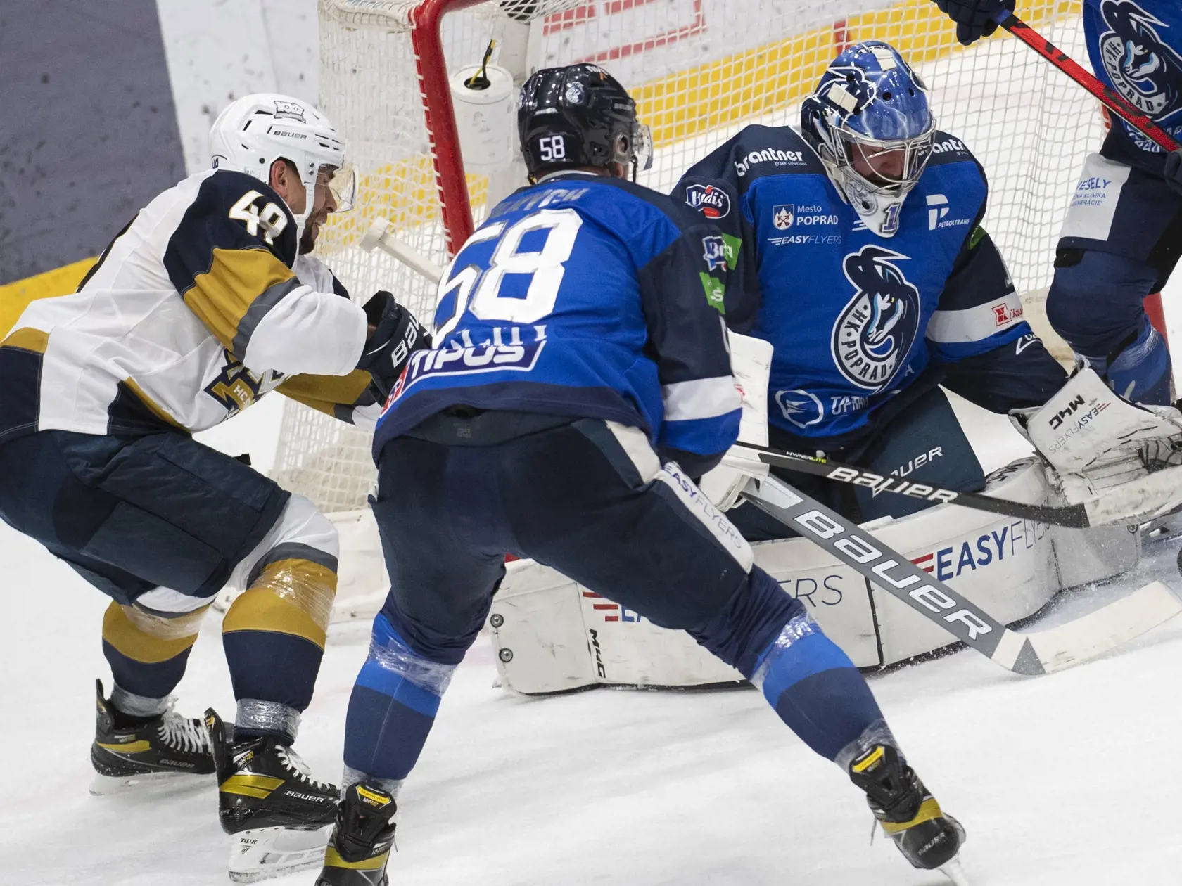Na snímke vľavo Samuel Takáč (Slovan), uprostred Petr Ulrych a vpravo brankár Marek Čiliak (Poprad) počas zápasu 10. kola hokejovej Tipos extraligy HC Slovan Bratislava - HK Poprad 21. októbra 2021 v Bratislave. FOTO TASR - Martin Baumann  
