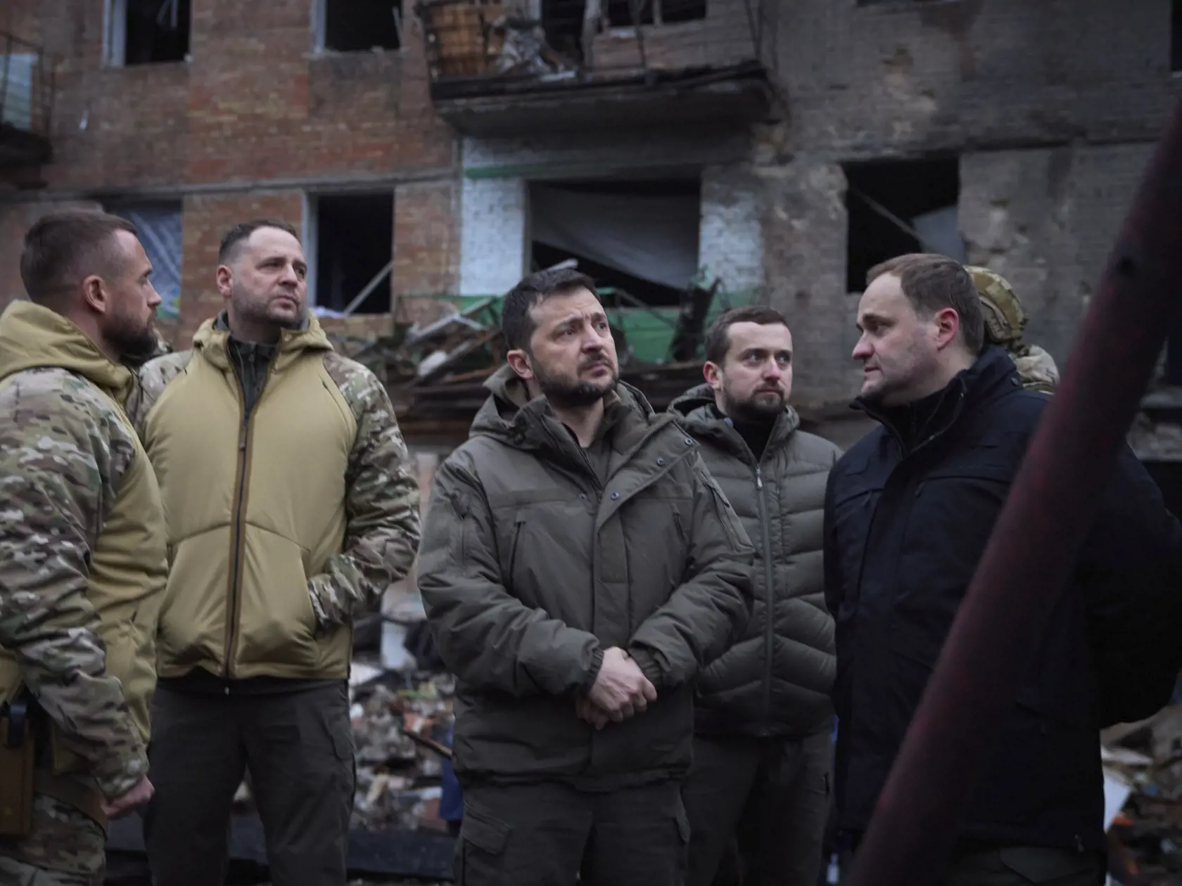 JB 32 Vyšgorod - Ukrajinský prezident Volodymyr Zelenskyj (uprostred) sa pozerá počas prehliadky zničených budov pri príležitosti jeho návštevy v meste Vyšgorod na predmestí Kyjeva 25. novembra 2022. Ukrajinský prezident Volodymyr Zelenskyj v piatok oznámil, že výpadky elektriny ešte trápia vyše šesť miliónov domácností na Ukrajine. Povedal to dva dni po mohutnom ruskom raketovom útoku cielenom na ukrajinskú energetickú infraštruktúru. TASR prevzala správu z tlačovej agentúry AFP. FOTO TASR/AP

