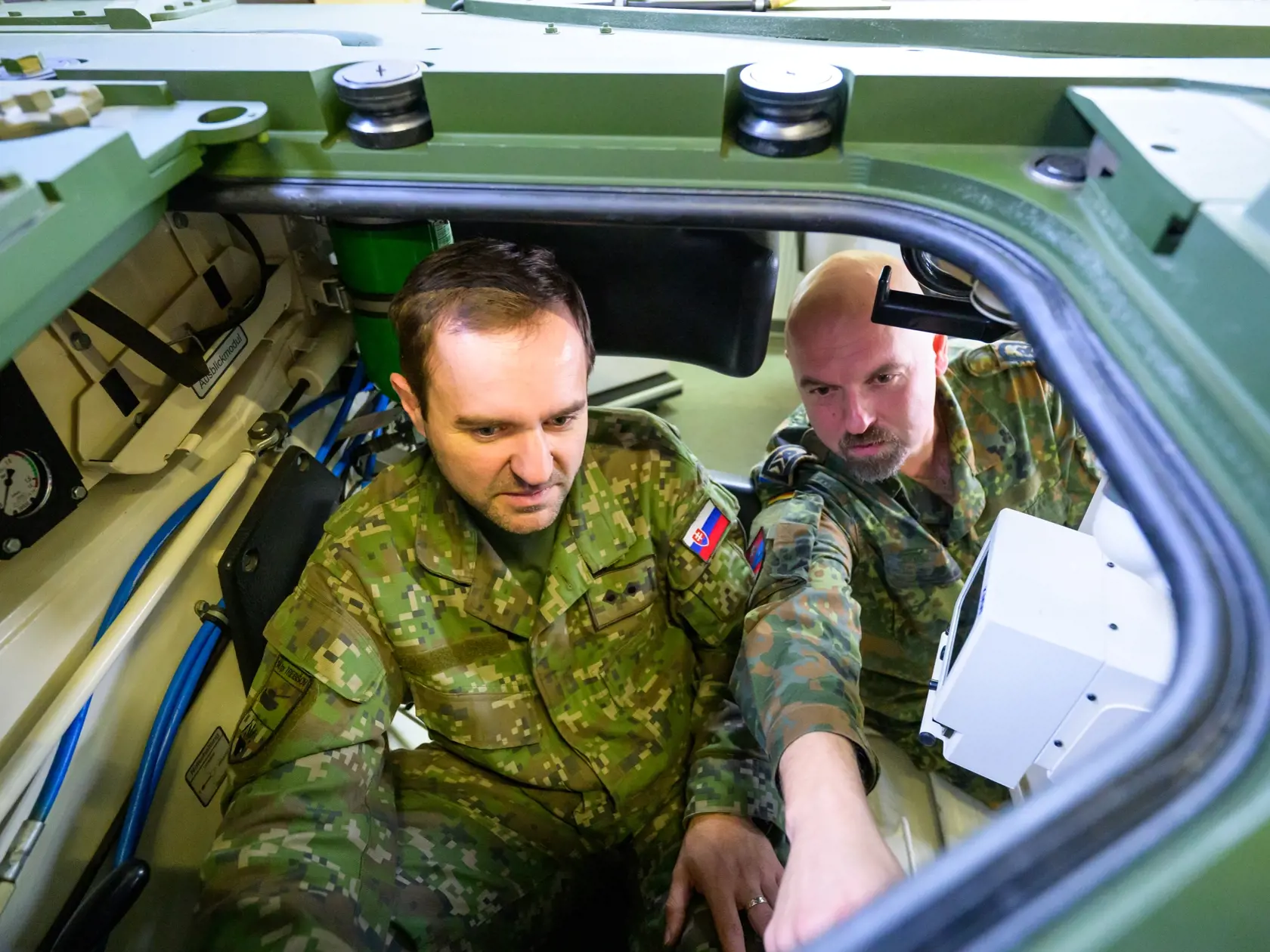 JB 6 Münster - Slovenský vojak (vľavo) nastupuje spolu s inštruktorom do bojového tanku Bundeswehru Leopard 2 A4 počas vojenského cvičenia vo výcvikovom stredisku v nemeckom meste Münster 24. novembra 2022. Nemecký Bundeswehr momentálne dáva výcvik slovenským vojenským vodičom na bojovom tanku typu Leopard 2 A4. Nemecká zbrojárska spoločnosť Rheinmetall dodá Slovensku v decembri tohto roka prvý z celkovo 15 tankov Leopard. FOTO TASR/DPA

24.11.2022, Niedersachsen, Munster: Ein slowakischer Solda