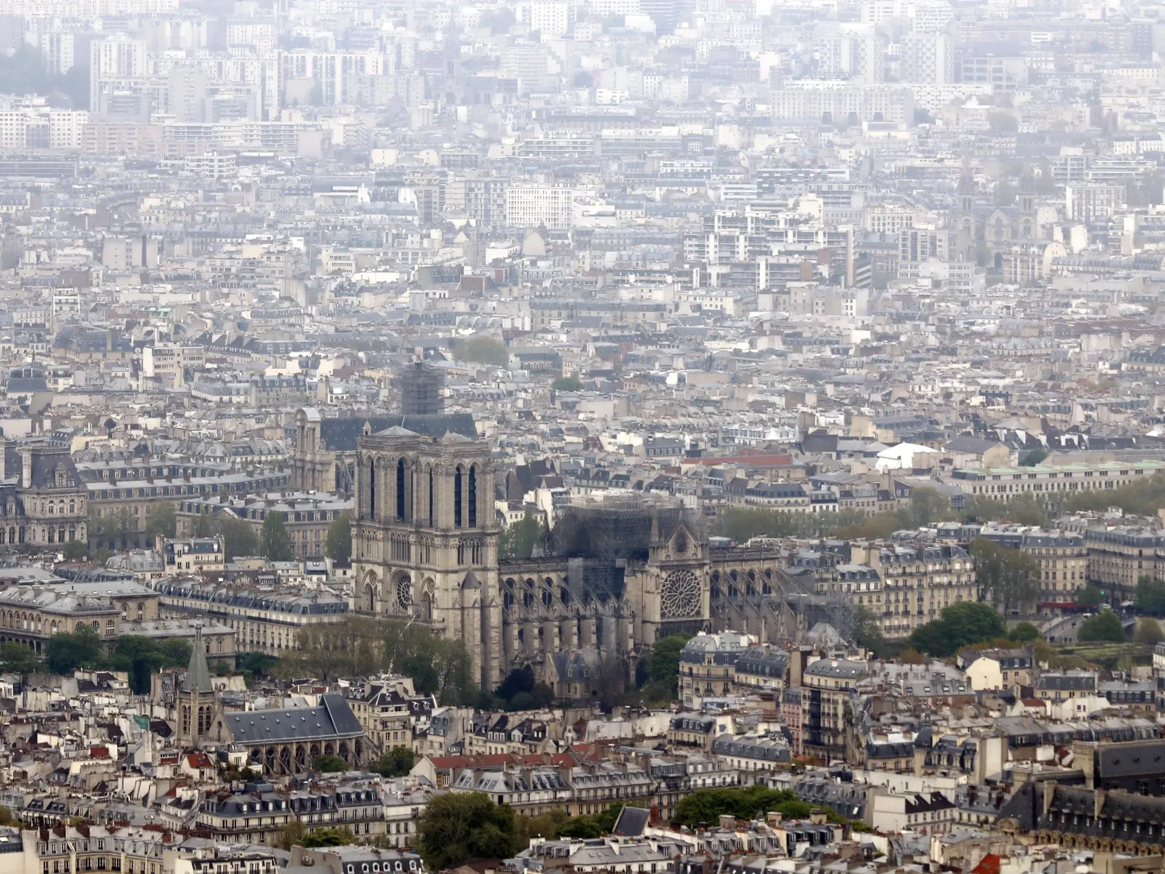 Notre Dame cathedral is pictured from the top of the Montparnasse tower, Tuesday April 16, 2019 in Paris. Firefighters declared success Tuesday morning in an over 12-hour battle to extinguish an inferno engulfing Paris' iconic Notre Dame cathedral that claimed its spire and roof, but spared its bell towers. (AP Photo/Thibault Camus)
