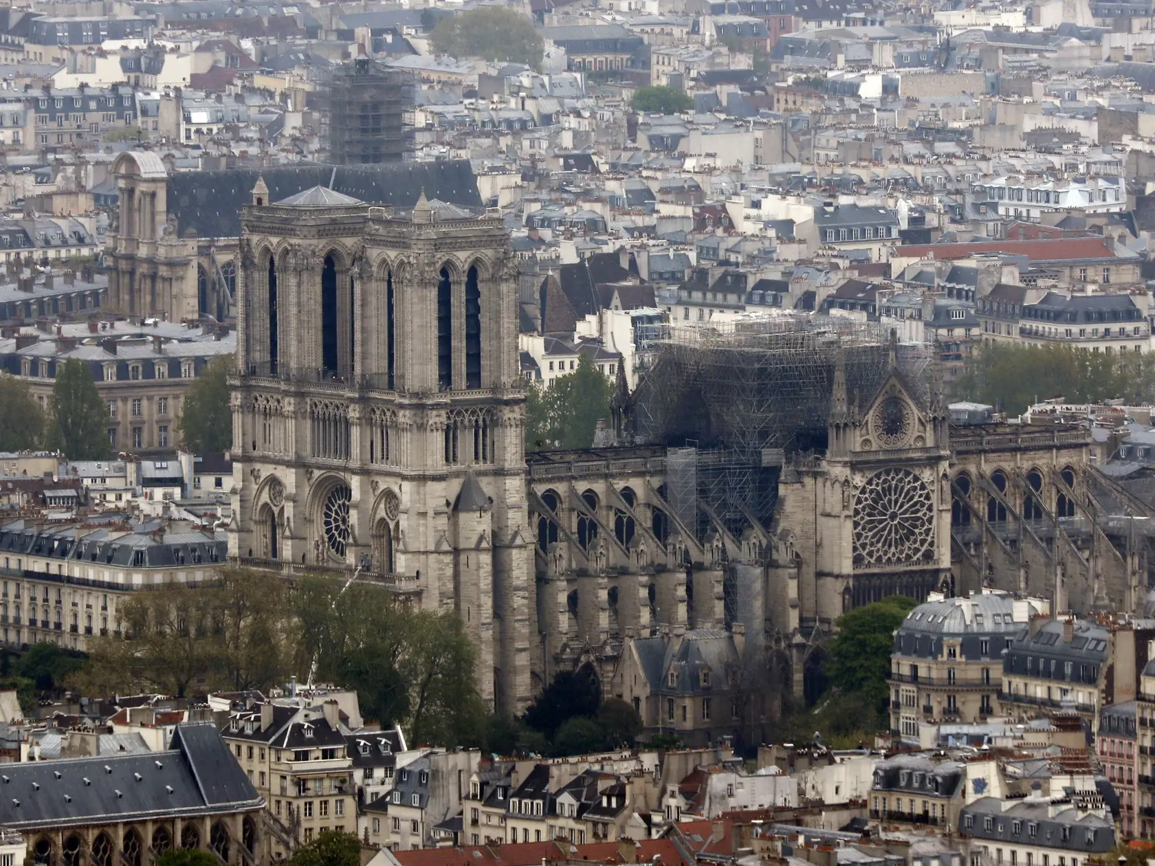Notre Dame cathedral is pictured from the top of the Montparnasse tower, Tuesday April 16, 2019 in Paris. Firefighters declared success Tuesday morning in an over 12-hour battle to extinguish an inferno engulfing Paris' iconic Notre Dame cathedral that claimed its spire and roof, but spared its bell towers. (AP Photo/Thibault Camus)
