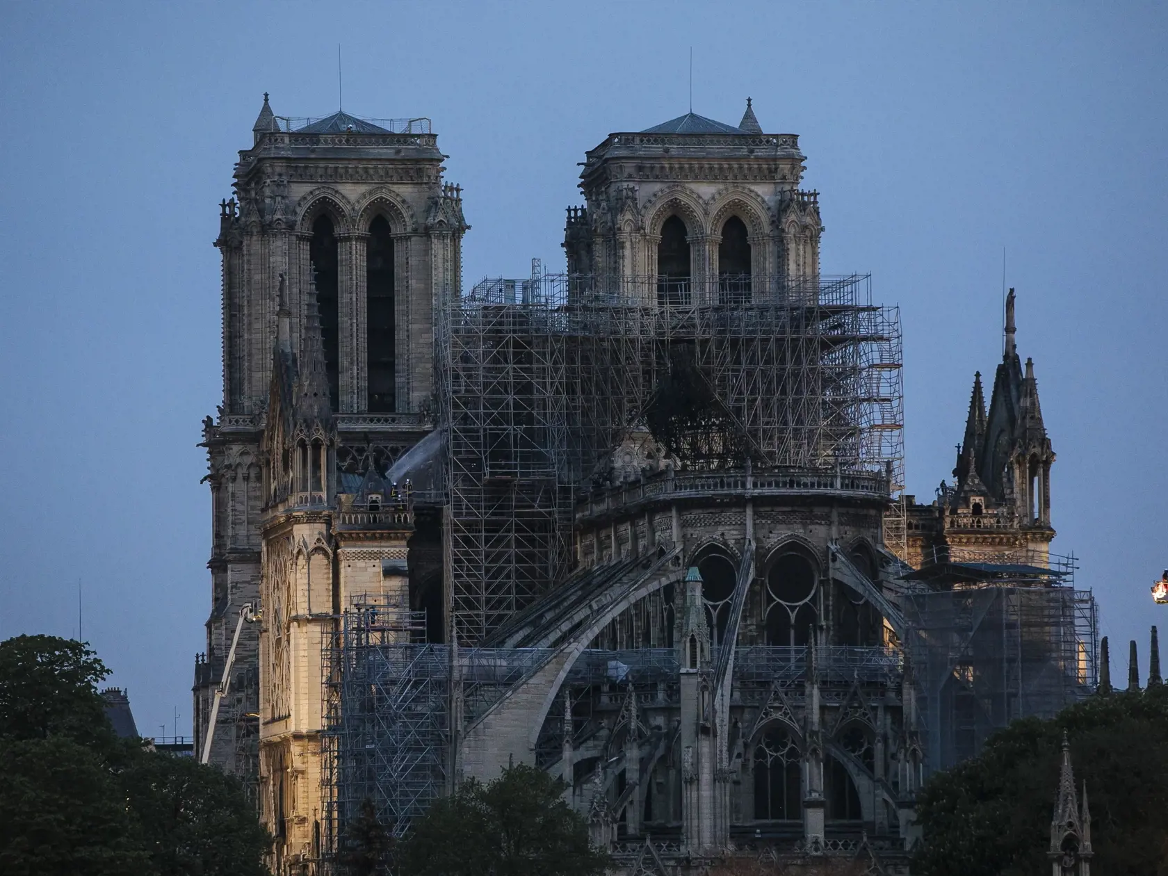 SY 26 Paríž - Na snímke parížska katedrála Notre Dame počas svitania po katastrofálnom požiari 16. apríla 2019. Požiar, ktorý vypukol v katedrále v pondelok pár minút pred 19. hodinou zničil strechu.Takmer štyrom stovkám hasičov sa podarilo po polnoci požiar dostať pod kontrolu. Oheň vypukol pravedepodobne v súvislosti s renovačnými prácami. FOTO TASR/AP
Firefighters operate on the Notre Dame cathedral after the fire in Paris, Tuesday, April 16, 2019. A catastrophic fire engulfed the upper reach