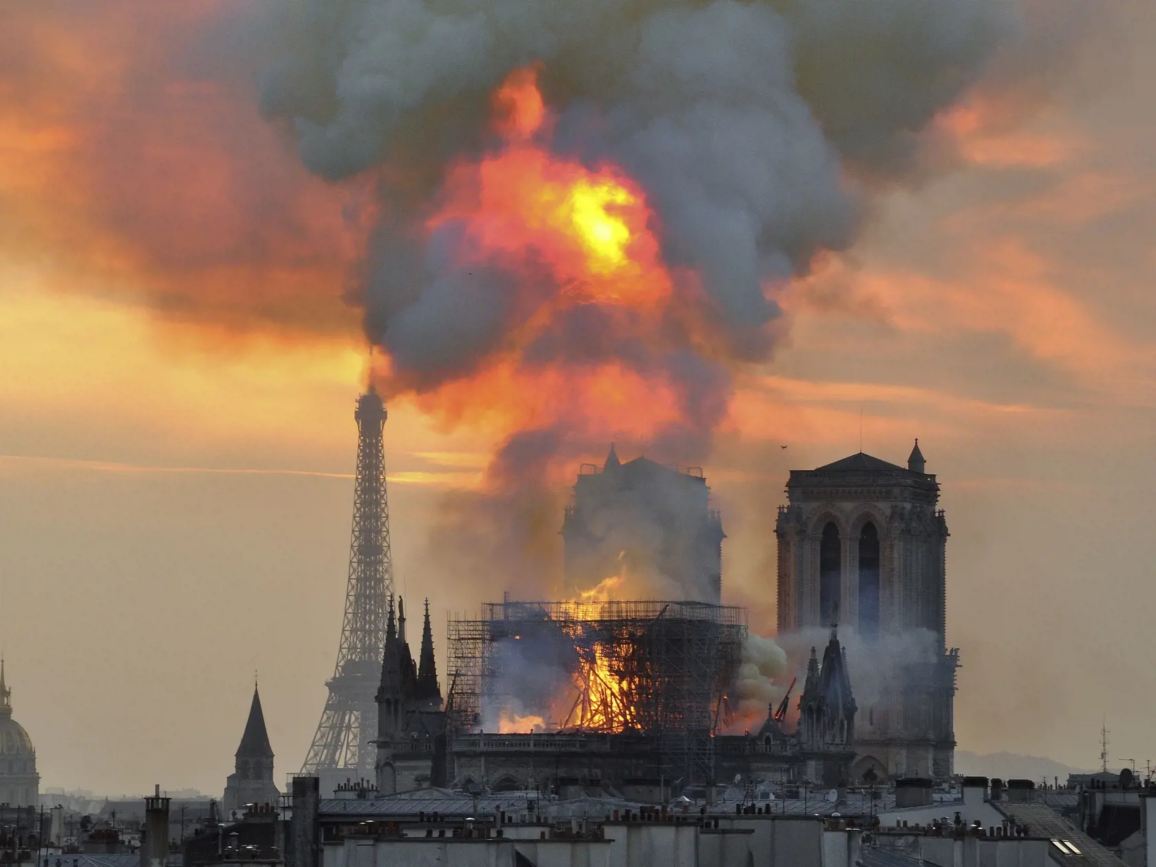 In this image made available on Tuesday April 16, 2019 flames and smoke rise from the blaze at Notre Dame cathedral in Paris, Monday, April 15, 2019. An inferno that raged through Notre Dame Cathedral for more than 12 hours destroyed its spire and its roof but spared its twin medieval bell towers, and a frantic rescue effort saved the monument's most
