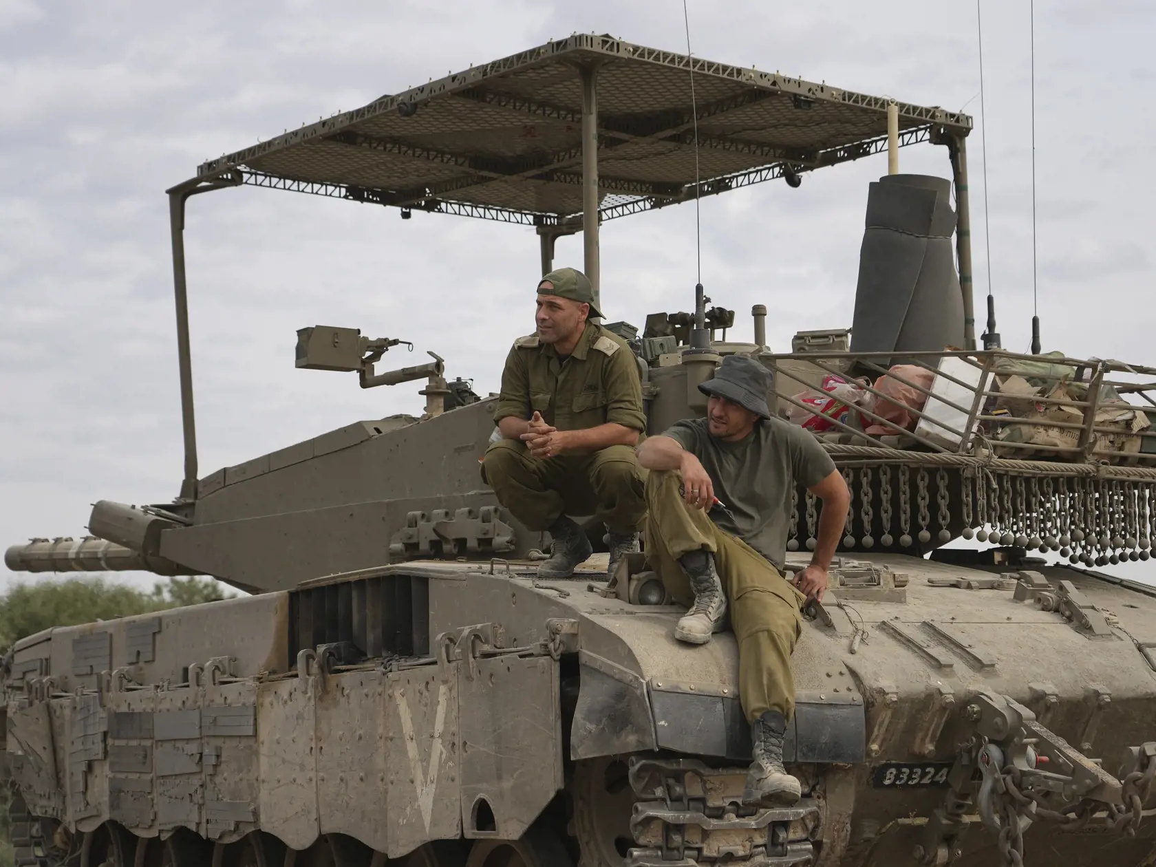 Izraelskí vojaci sedia na tanku v armádnej zóne neďaleko izraelskej hranice s Pásmom Gazy na juhu Izraela v sobotu 25. novembra 2023. Izrael v sobotu v rámci druhého dňa prímeria s palestínskym militantným hnutím Hamas v Pásme Gazy prepustí 42 palestínskych väzňov. Hamas výmenou za to prepustí 14 rukojemníkov zadržiavaných v pásme Gazy od 7. októbra.