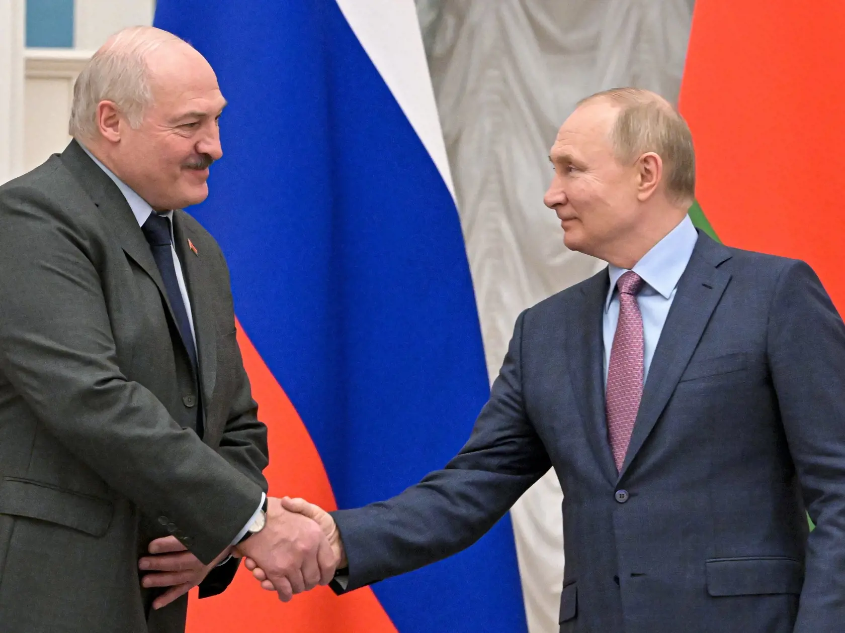 Bieloruský prezident Alexandr Lukašenko (vľavo) a ruský prezident Vladimir Putin si podávajú ruky po spoločnej tlačovej konferencii v Moskve v piatok 18. februára 2022.