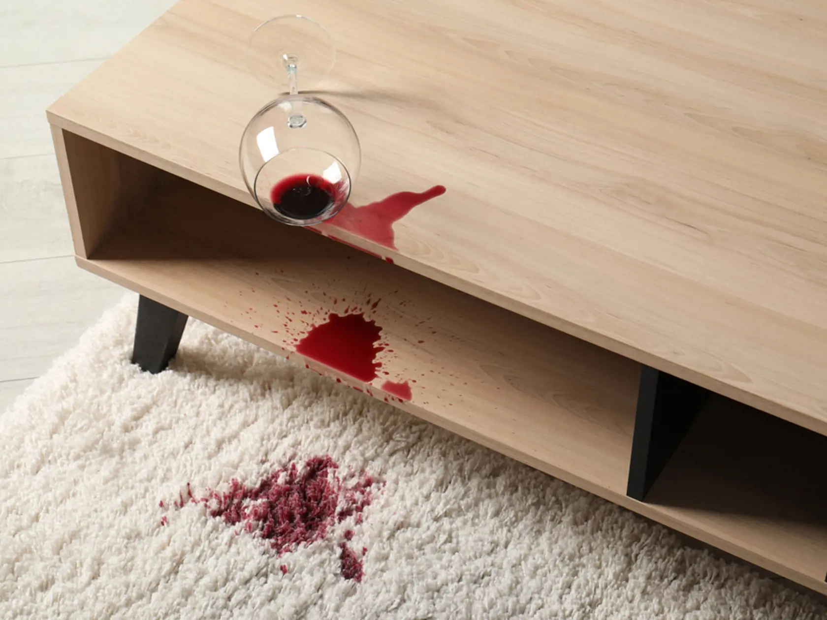 Overturned,Glass,And,Spilled,Red,Wine,On,White,Carpet,Indoors