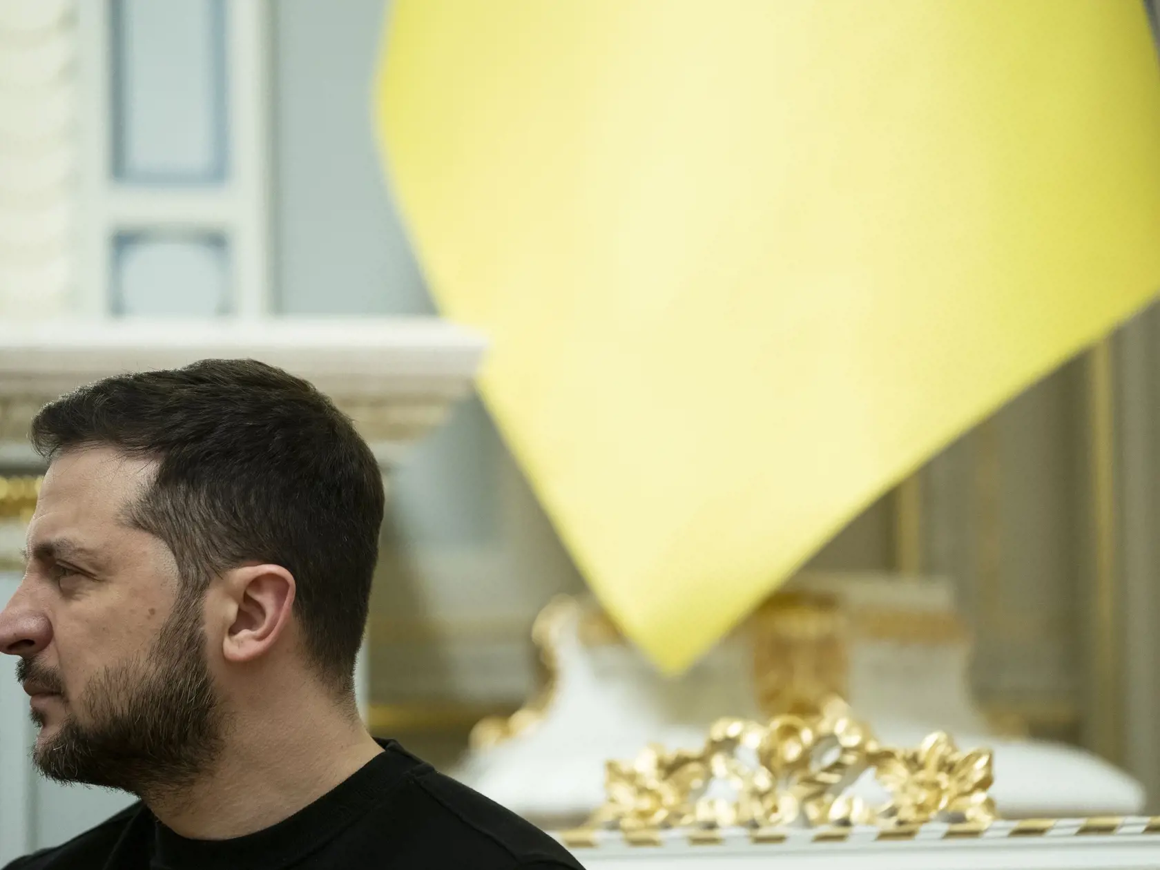 Ukrajinský prezident Volodymyr Zelenskyj počúva amerického prezidenta Joea Bidena počas tlačovej konferencie v Kyjeve v pondelok 20. februára 2023.