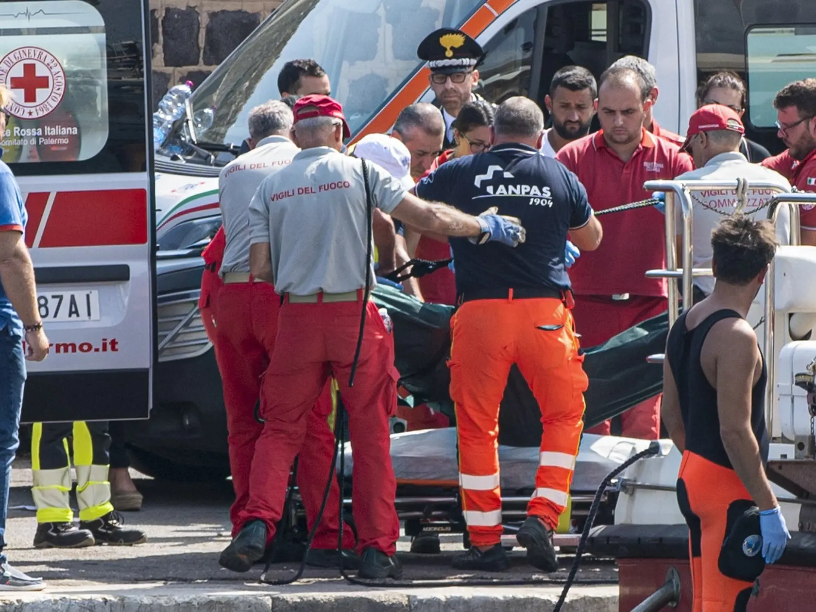 Záchranári vynášajú telo jednej z obetí plachetnice Bayesan plaviacej sa pod britskou zástavou po tom, ako sa potopila počas búrky v Stredozemnom mori pri pobreží sicílskej dedinky Porticello neďaleko Palerma na talianskom ostrove Sicília 19. augusta 2024.