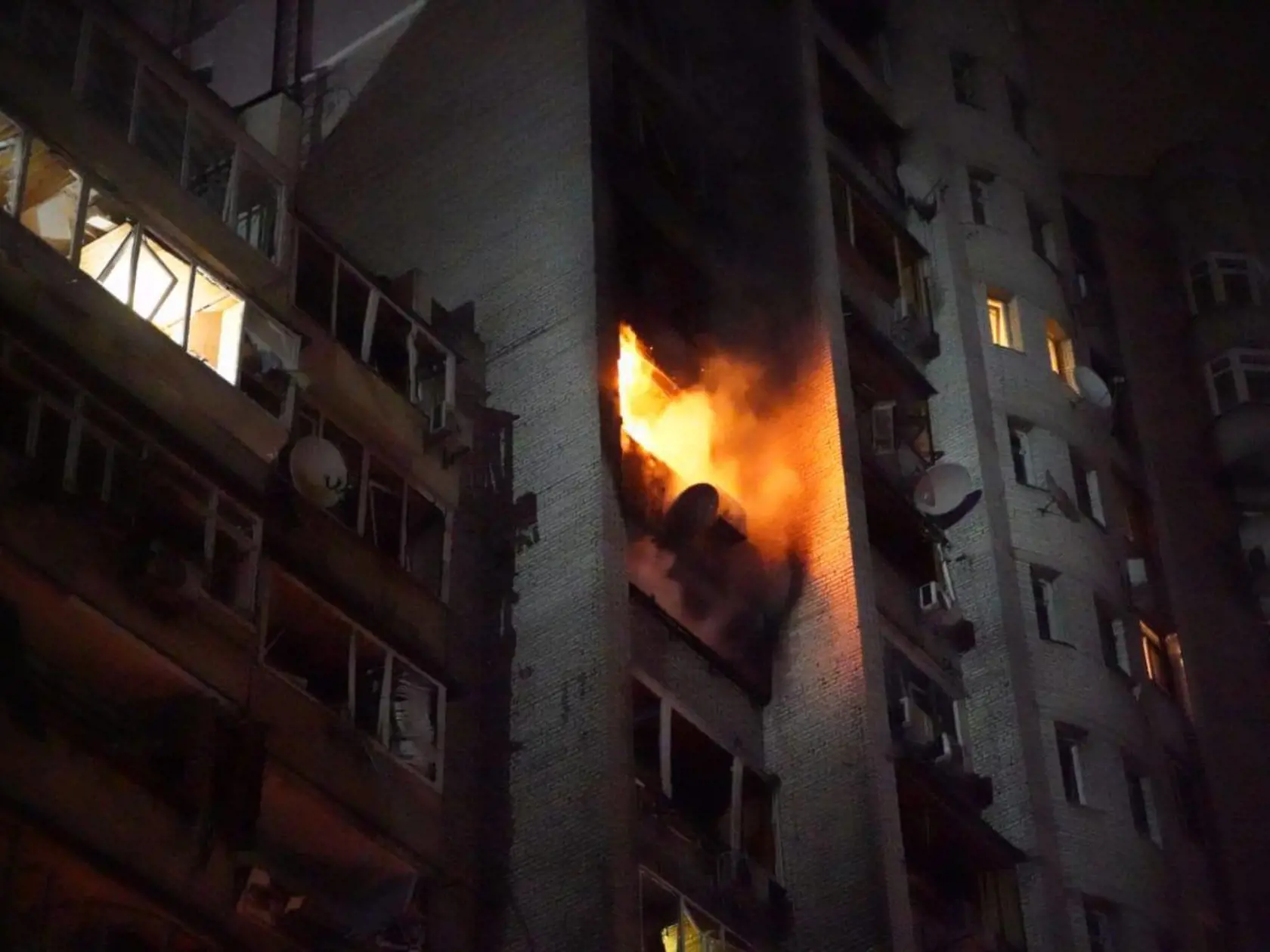 Kyjevská bytovka v plameňoch po zasiahnutí troskami zostreleného ruského lietadla.