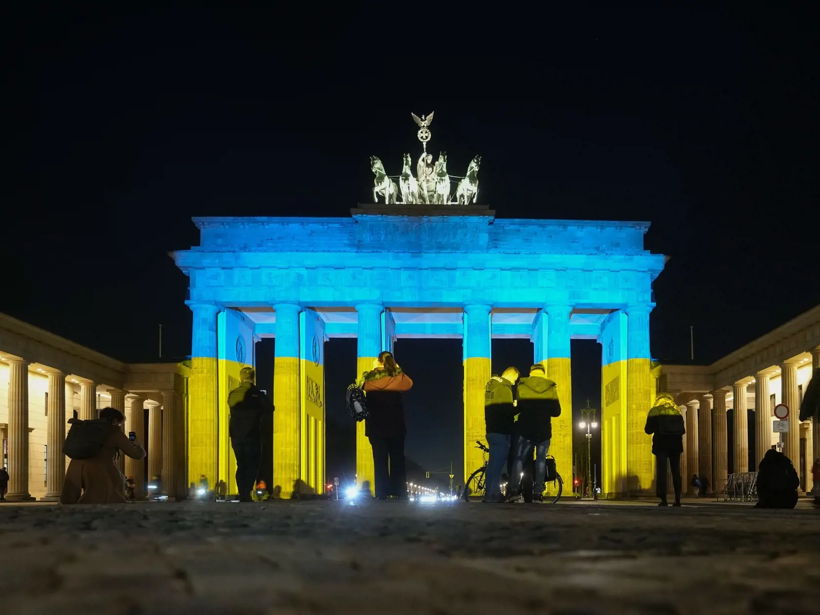 WA 37 Berlín -  Ľudia sa pozerajú na Brandenburskú bránu v Berlíne, ktorá je vysvietená v národných farbách Ukrajiny v stredu 23. februára 2022. 

   
People look at the Brandenburg Gate after it was illuminated in the colours of the Ukrainian flag to show solidarity with the country during the tensions with Russia in Berlin, Germany, Wednesday, Feb. 23, 2022. (AP Photo/Markus Schreiber)
