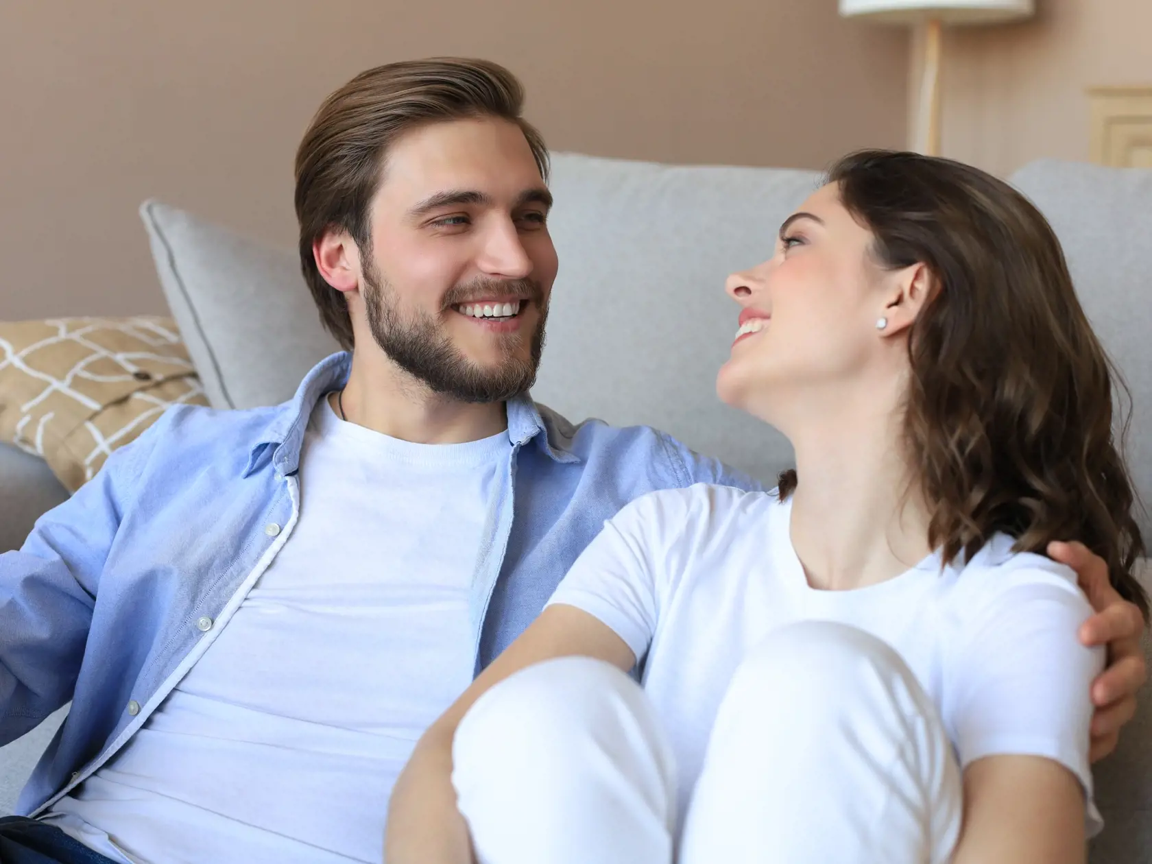 Young,Loving,Couple,Relaxing,On,Floor,Near,Sofa,Together.,Woman