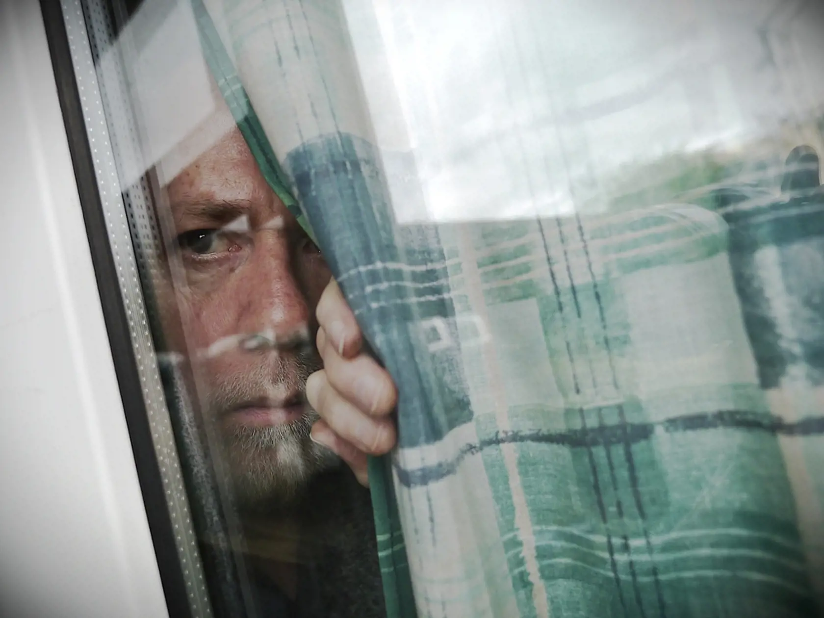 Anxious,Or,Suspicious,Man,Peeping,Through,Window,From,Behind,Curtain