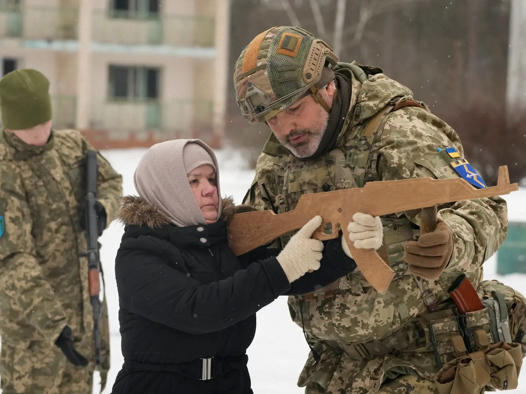 Inštruktor trénuje Rumiu (59), členku ukrajinských síl teritoriálnej obrany, neďaleko Kyjeva na Ukrajine 5. februára 2022. Nikto z trojice zrejme vtedy netušil, že v krátkom čase budú držať v rukách skutočné zbrane.