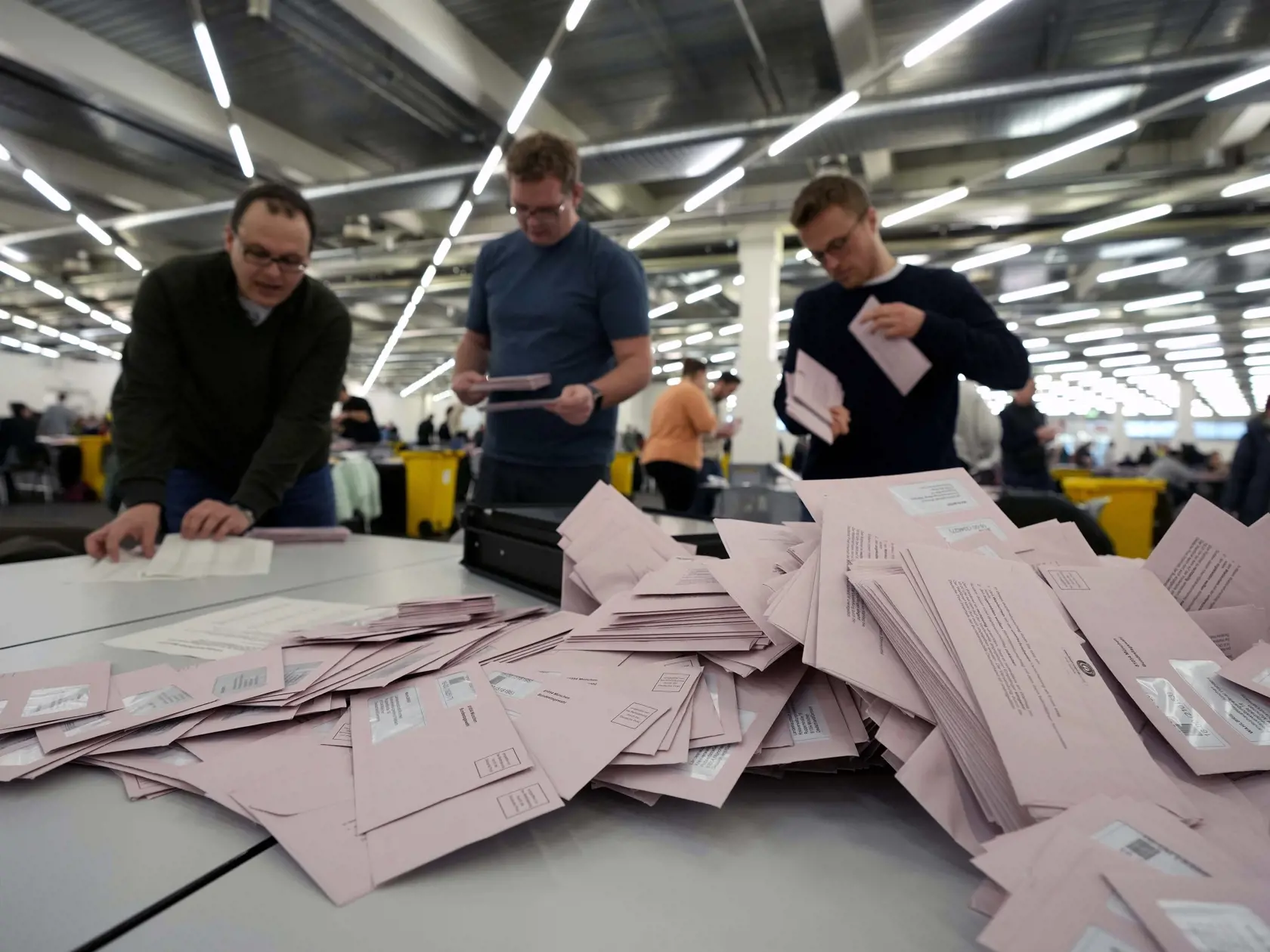 Dobrovoľníci pripravujú hlasovacie lístky počas predčasných parlamentných volieb v Nemecku v nedeľu 23. februára 2025 v Mníchove.