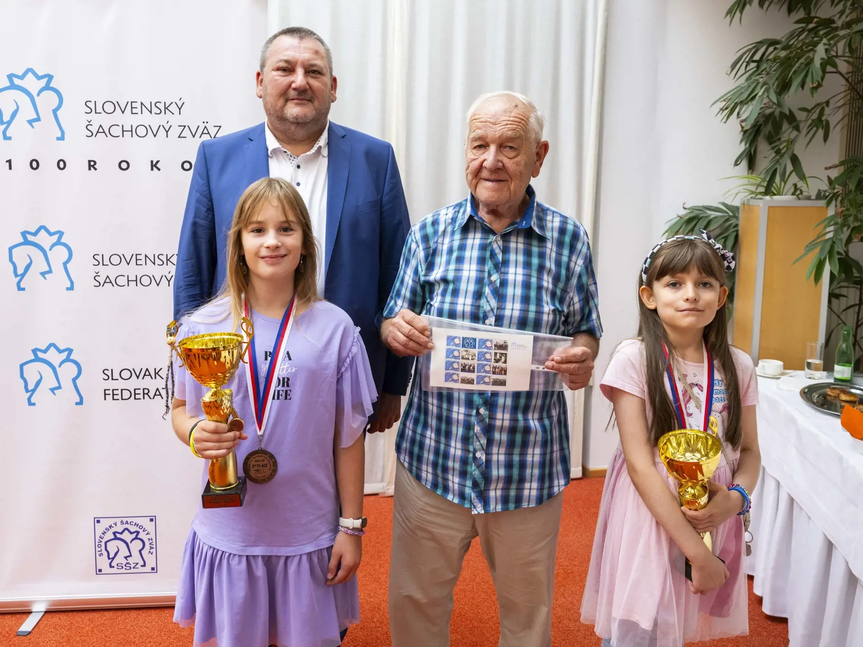 Na snímke zľava hore prezident Slovenského šachového zväzu Milan Roman, šachový veľmajster Ján Plachetka a európske bronzové medailistky z ME mládeže v šachu Simona Kováčiková a Bianka Macáková počas tlačovej konferencie Slovenského šachového zväzu (SŠZ) k 100. výročiu založenia a blížiacimi sa turnajmi 5. septembra 2024 v Bratislave. FOTO TASR - Jakub Kotian
