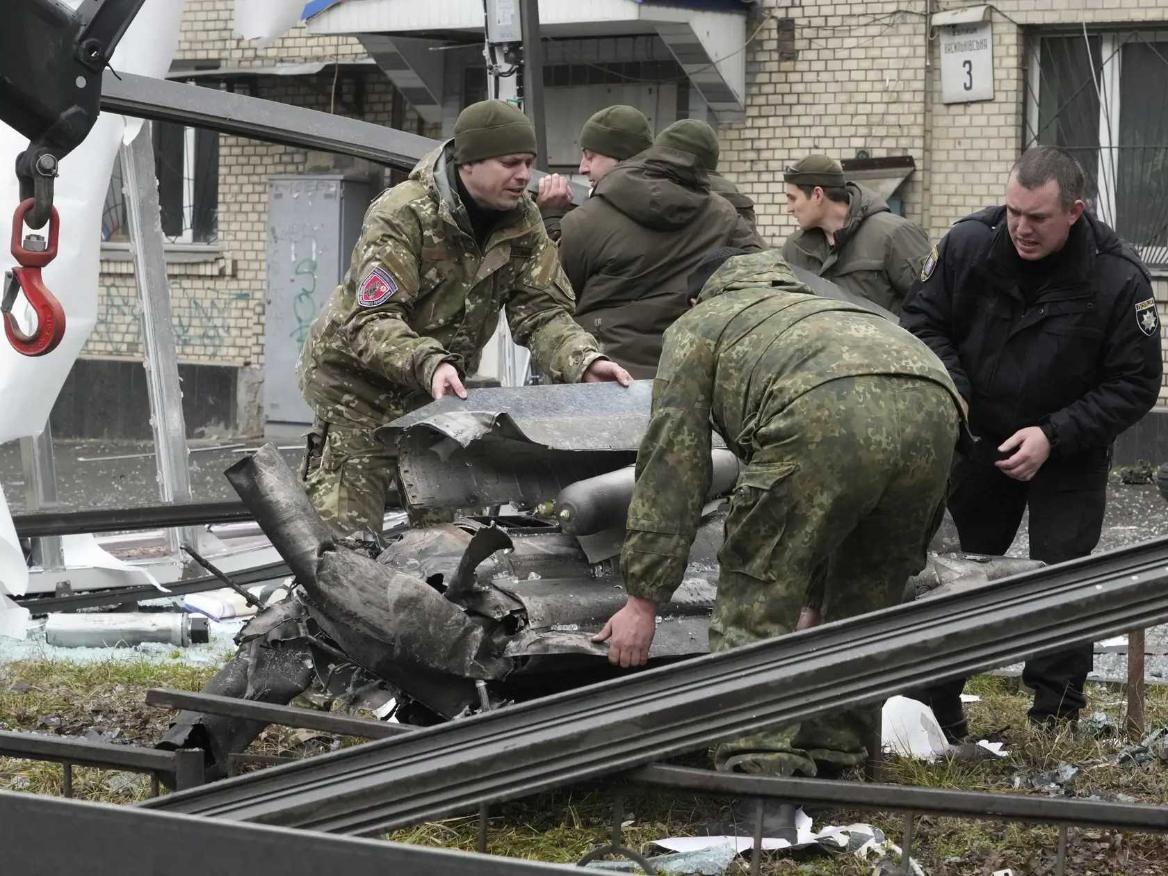 Na snímke pracovníci sa pripravujú na naloženie častí rakety po ostreľovaní ruskej armády v Kyjeve.