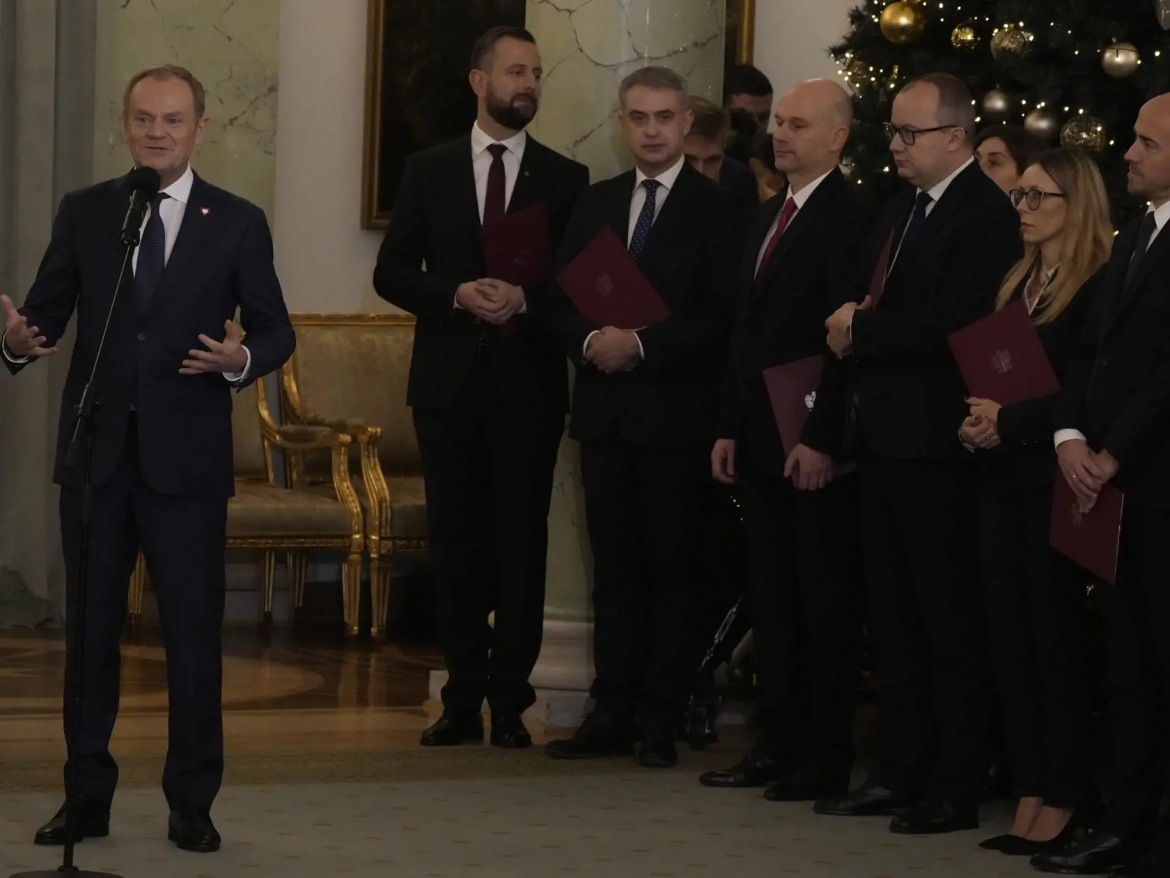 Poľský premiér Donald Tusk (vľavo) sa prihovára k členom nového vládneho kabinetu a ostatným prítomným počas slávnostného vymenovania novej vlády vo Varšave 13. decembra 2023. Nový poľský premiér Donald Tusk zložil v stredu prísahu do rúk prezidenta Andrzeja Dudu. TASR informuje podľa správy agentúry AP. Počas ceremómnie v prezidentskom paláci vo Varšave zložia prísahu všetci ministri novej Tuskovej vlády.