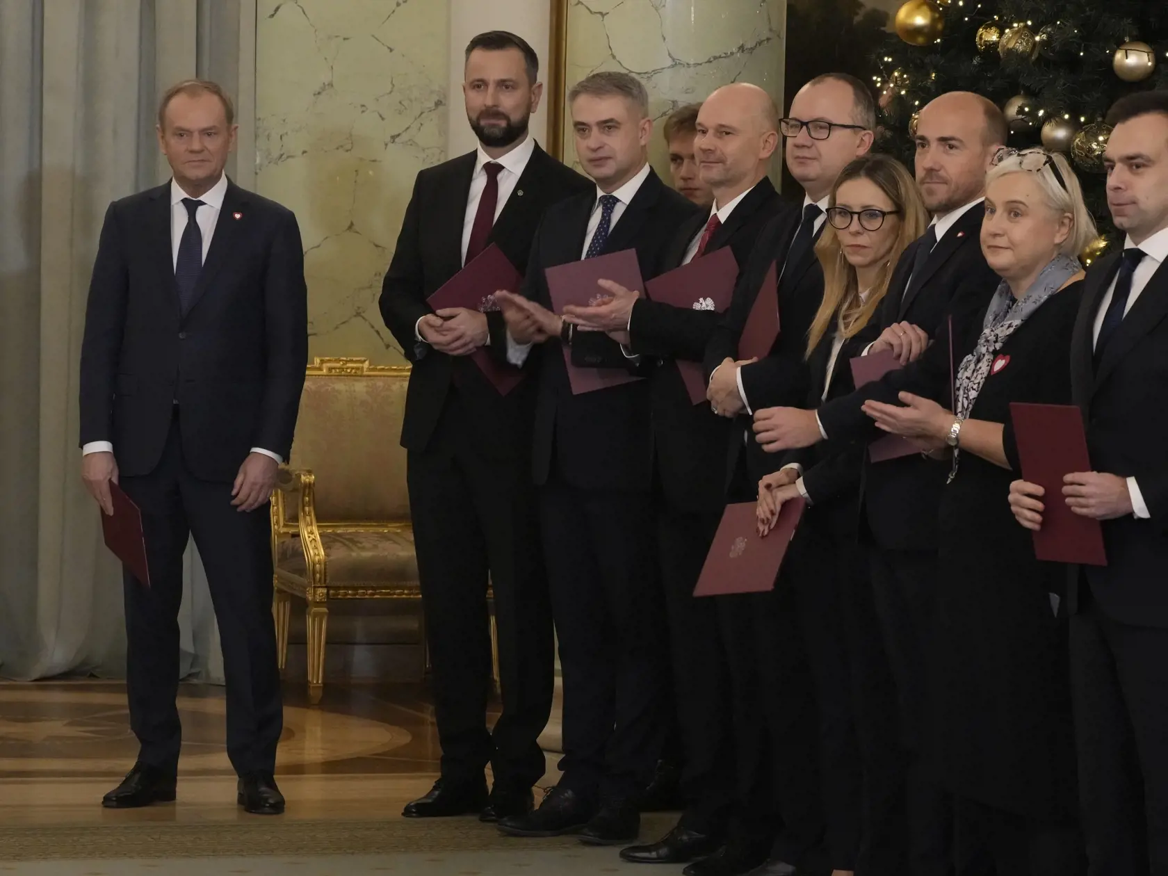 Poľský premiér Donald Tusk (vľavo) stojí pri svojich ministroch počas slávnostného vymenovania novej vlády vo Varšave 13. decembra 2023. Nový poľský premiér Donald Tusk zložil v stredu prísahu do rúk prezidenta Andrzeja Dudu. TASR informuje podľa správy agentúry AP. Počas ceremómnie v prezidentskom paláci vo Varšave zložia prísahu všetci ministri novej Tuskovej vlády.