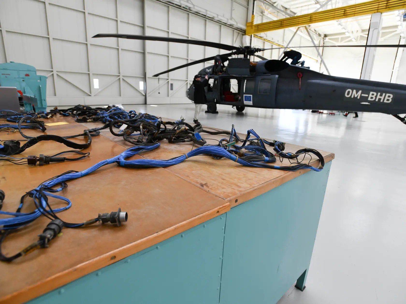 Na snímke súčiastky a pracovníci počas opravy vrtuľníka Sikorsky UH 60A Black Hawk v hangári Leteckých opravovní Trenčín a.s. (LOTN) v Trenčíne v stredu 9. apríla 2025. V štátnej spoločnosti Letecké opravovne Trenčín (LOTN) budú opravovať lietadlá F-16. Dohodu o založení spoločnej organizácie na opravu a údržbu lietadiel F-16 podpísali v stredu riaditeľ LOTN Juraj Lauš a prezident nórskej spoločnosti Kongsberg Aviation Maintenance Services (KAMS) André Jaegtvik. FOTO TASR - Martin Medňanský

