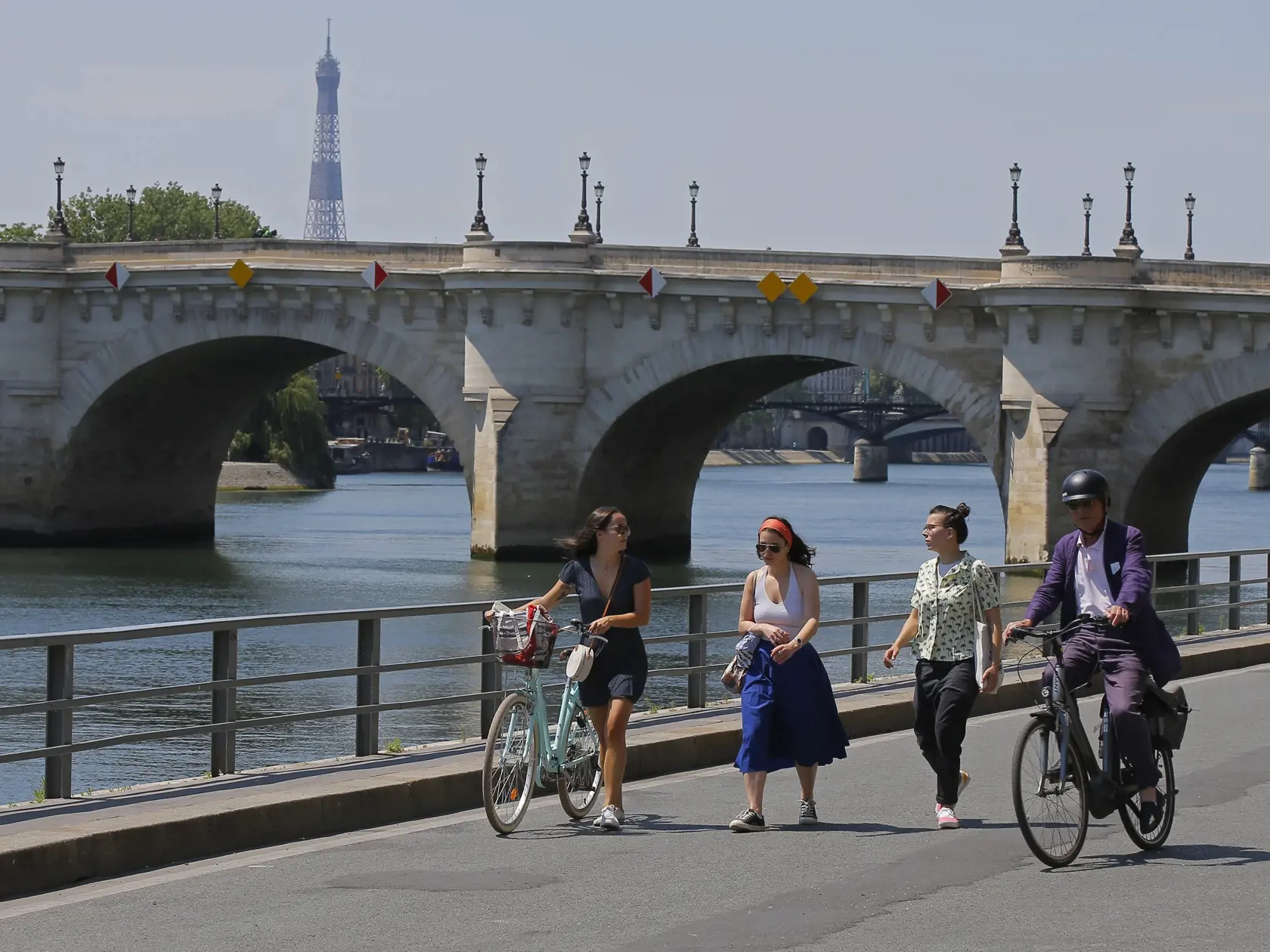 Ľudia sa prechádzajú pri brehu Seiny počas horúceho dňa v Paríži.