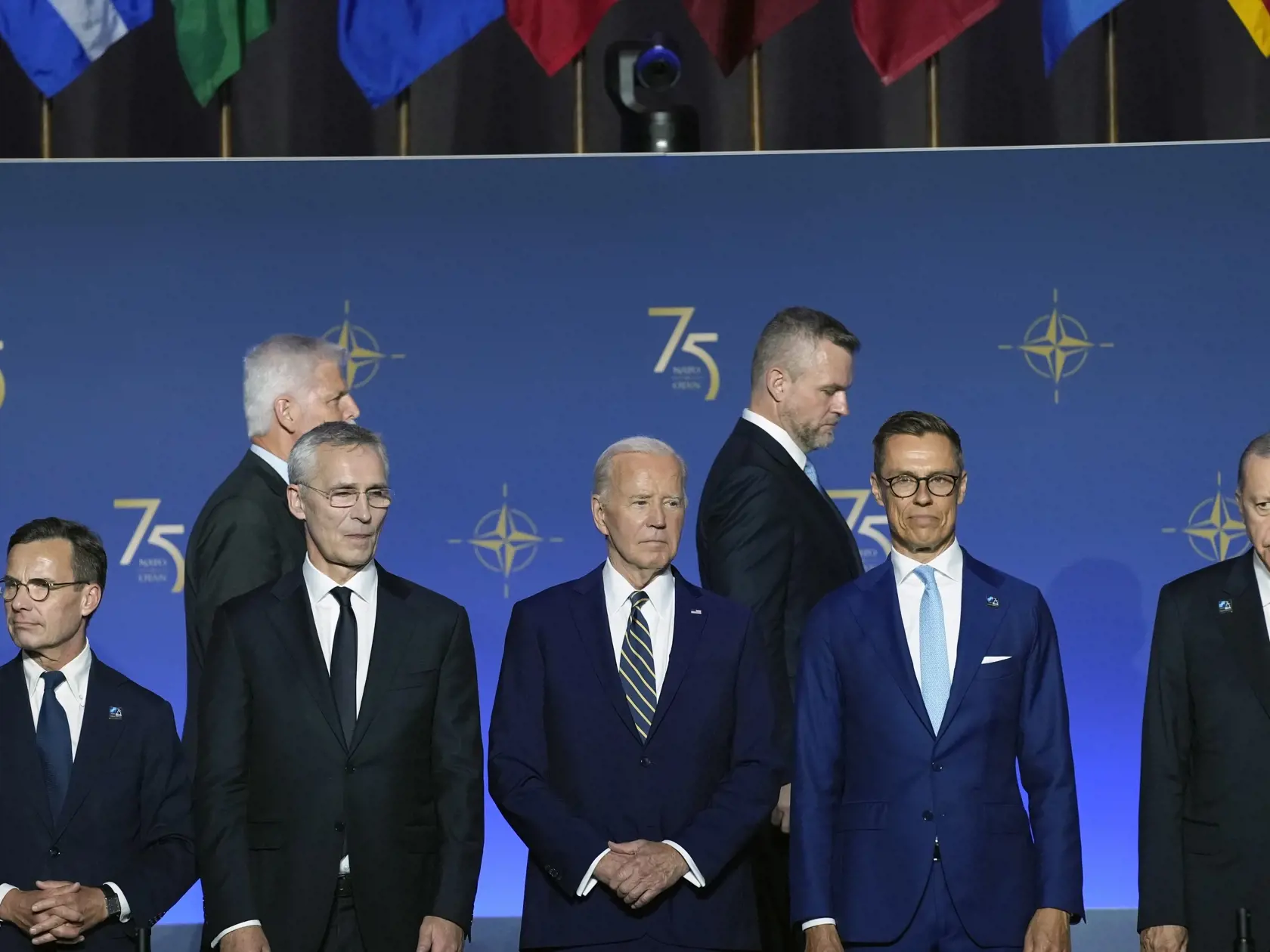 EBE 64 Washington - Účastníci summitu NATO vo Washingtone prichádzajú na skupinové fotografovanie 9. júla 2024. Na snímke v pozadí tretí zľava prezident SR Peter Pellegrini. FOTO TASR/AP

President Joe Biden, center, stands as others arrive during an event commemorating the 75th Anniversary of NATO at the Andrew W. Mellon Auditorium on the sidelines of the NATO summit in Washington on Tuesday, July 9, 2024. (AP Photo/Susan Walsh)