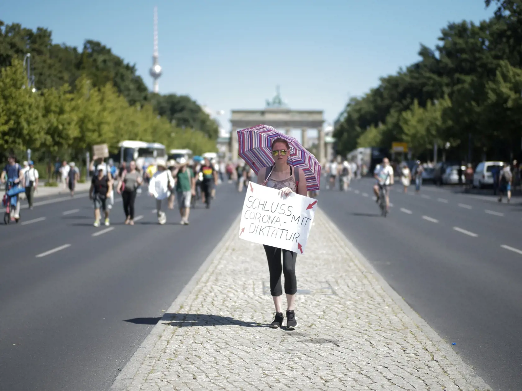 Demonštrantka bez ochranného rúška drží transparent s nápisom Koniec koronavírusovej diktatúre na proteste pod heslom  "Koniec pandémii: Deň slobody" proti reštrikciám zavedeným nemeckou vládou za účelom zastaviť šírenie koronavírusovej pandémie v Berlíne.