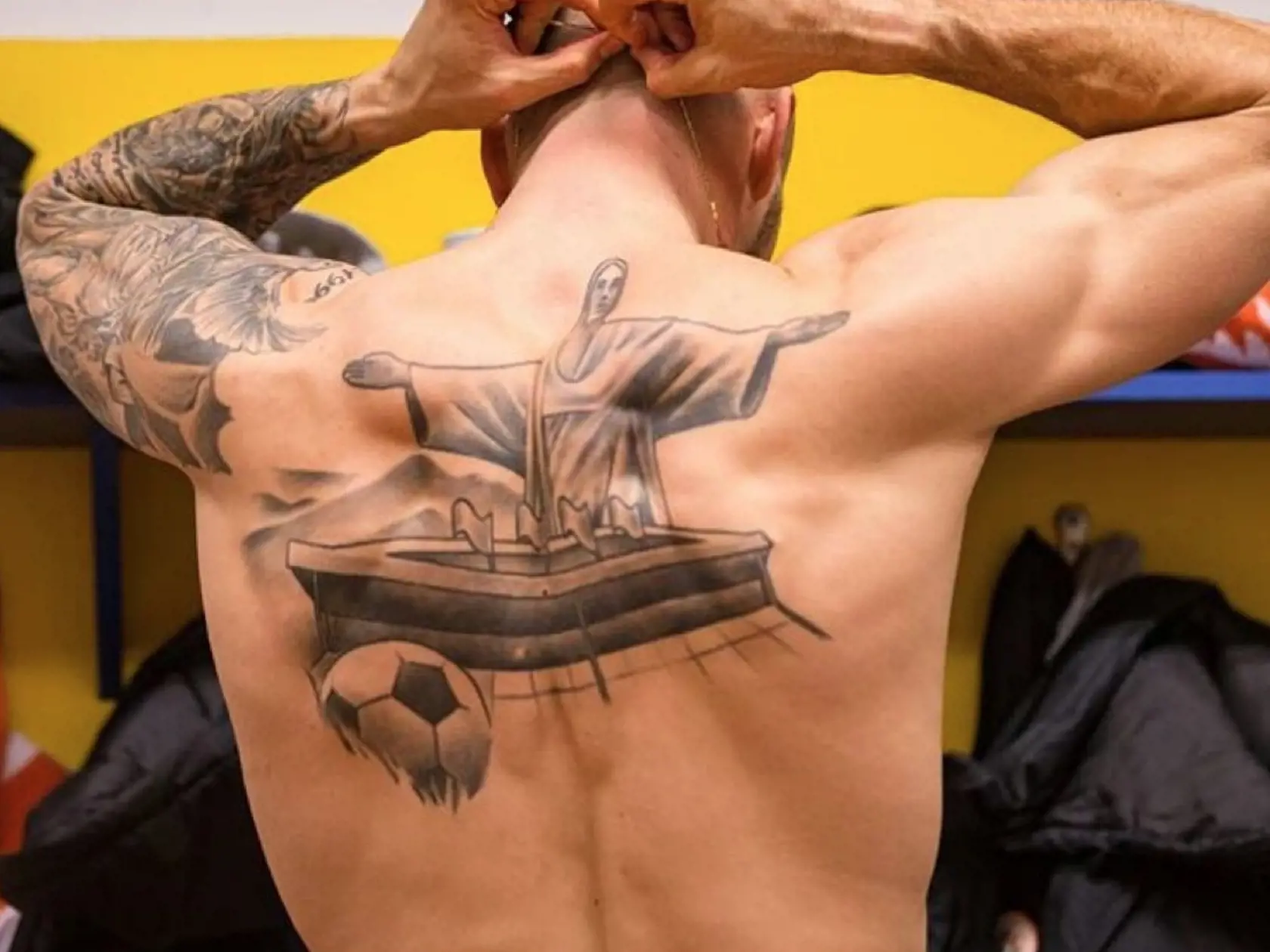 Chrbát futbalistu zdobí socha z Ria a štadión s loptou.