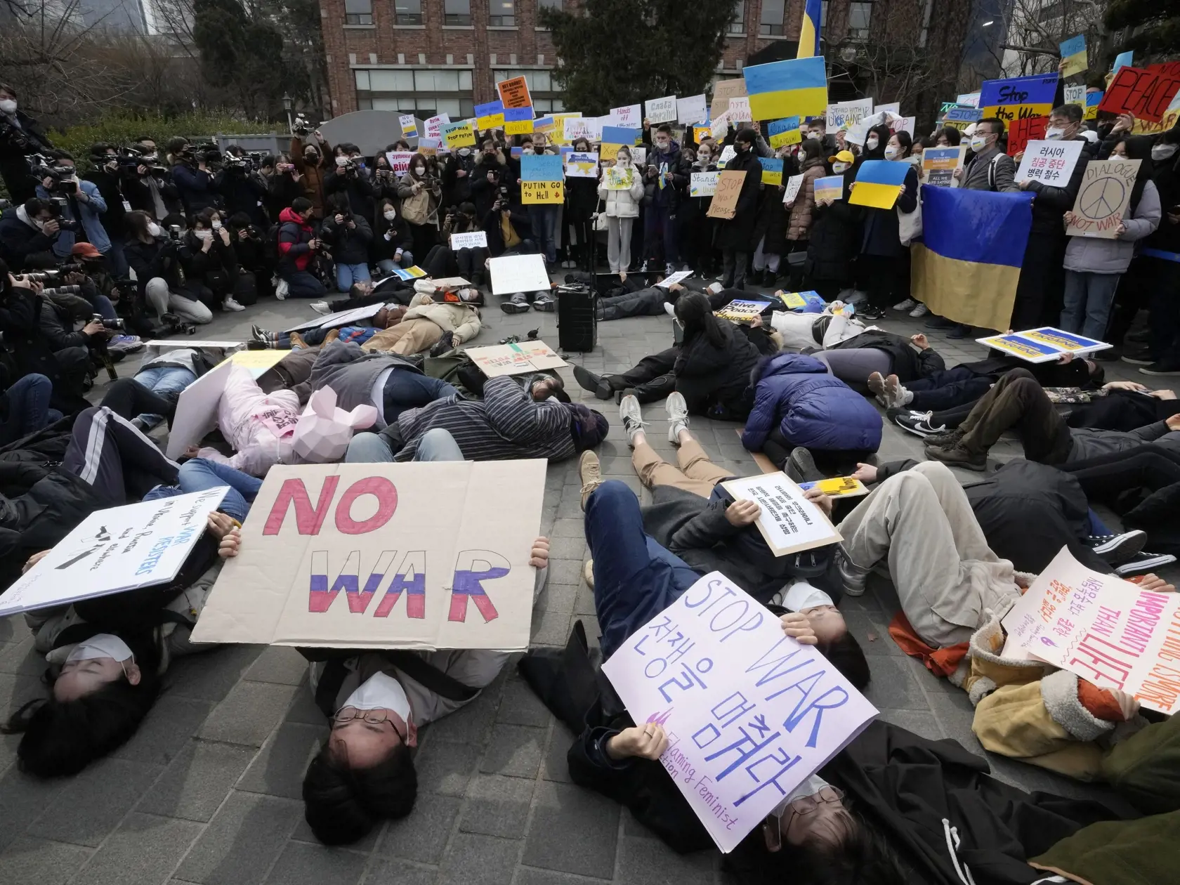 PK 23 Soul - Demonštranti ležia na zemi počas protestu proti ruskej invázii na Ukrajine neďaleko ruskej ambasády v Soule v pondelok 28. februára 2022. FOTO TASR/AP