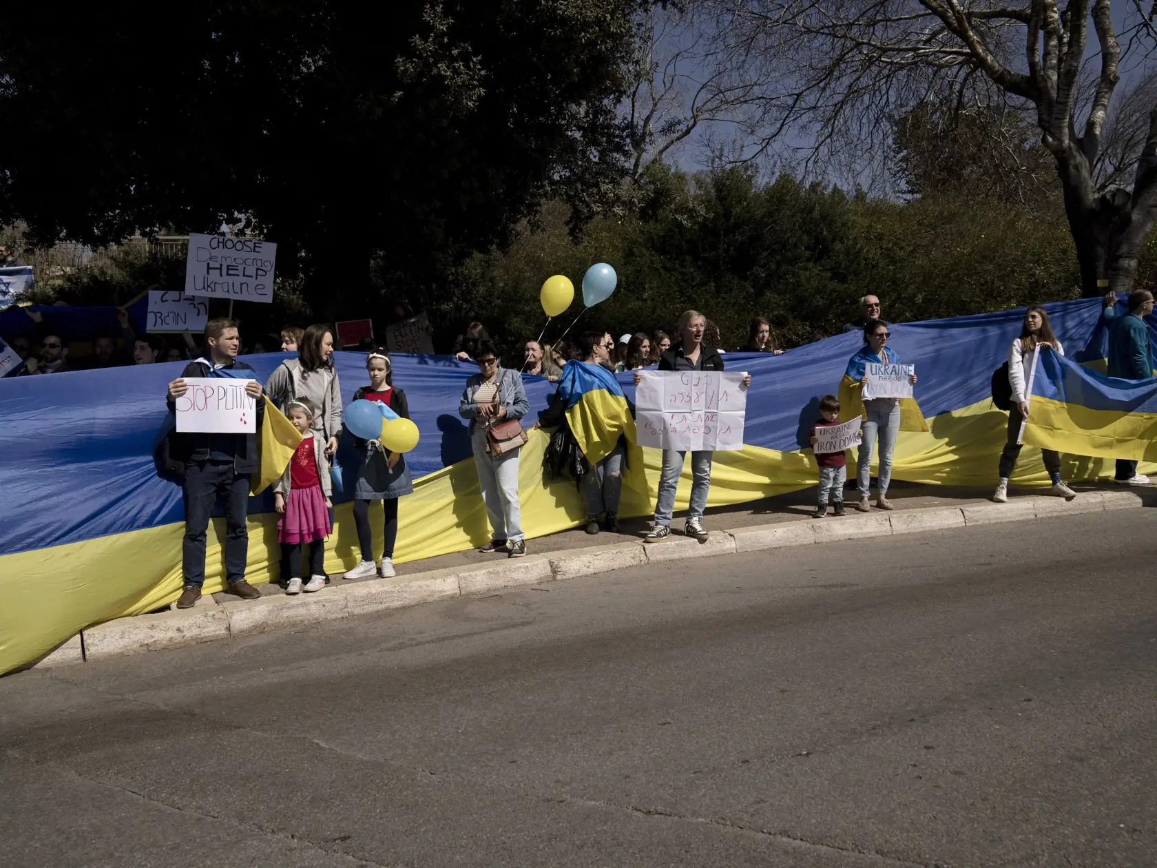 PK 36 Jeruzalem - Ľudia stoja pred ukrajinskou vlajkou počas protestu proti ruskej invázii na Ukrajine pred budovou parlamentu v Jeruzaleme v pondelok 28. februára 2022. FOTO TASR/AP