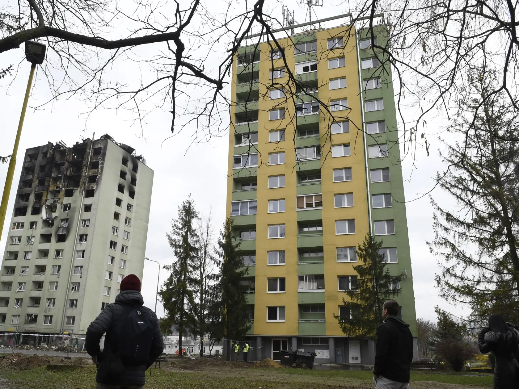Na snímke vľavo 12-podlažná bytovka na Mukačevskej ulici, ktorú poškodil výbuch plynu 6. decembra a budú ju musieť zbúrať. Vpravo bytovka, do ktorej sa mali po jej kontrole vrátiť jej obyvatelia 10. decembra 2019. Viaceré okná tejto bytovky budú musieť zaskliť. Nešťastie si vyžiadalo sedem obetí, jedna osoba je nezvestná a desiatky ďalších utrpeli zranenia. Prešov 10. decembra 2019. FOTO TASR - Milan Kapusta
