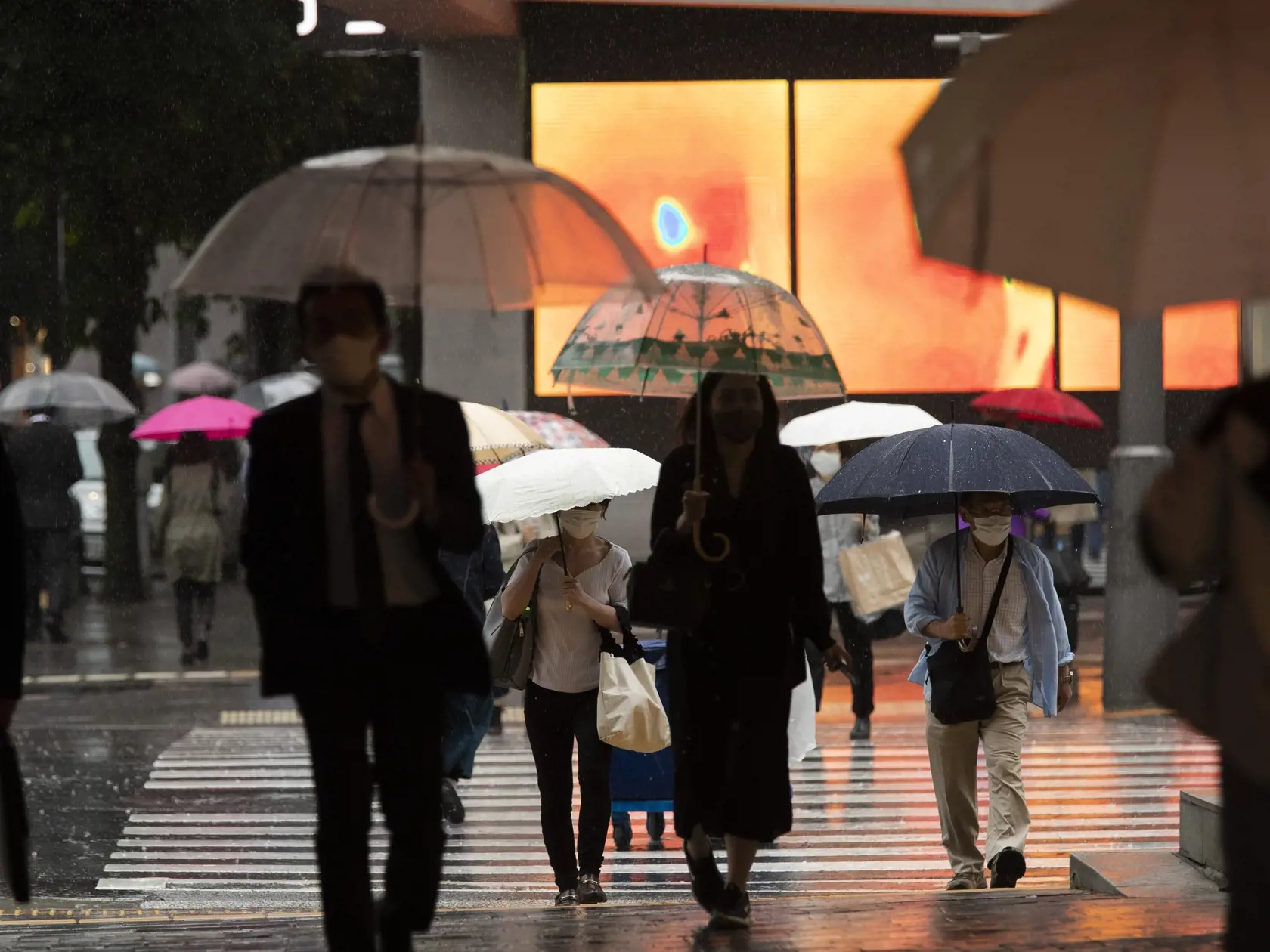 EBE 38 Tokio - Na snímke ľudia s ochrannými rúškami prechádzajú prechádzajú cez križovatku v známej nákupnej štvrti Ginza v daždivom dni v japonskom Tokiu 27. mája 2021. FOTO TASR/AP

People wearing face masks walk across an intersection in the famed Ginza shopping area on a rainy day in Tokyo on Thursday, May 27, 2021. (AP Photo/Hiro Komae)