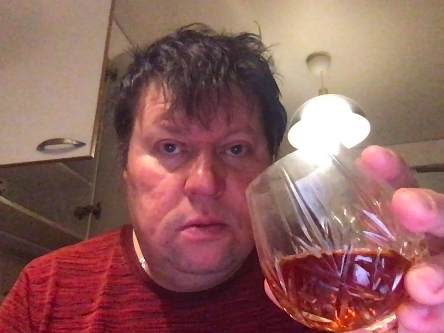 Dominikin manžel sa fotil, ako pije alkohol.