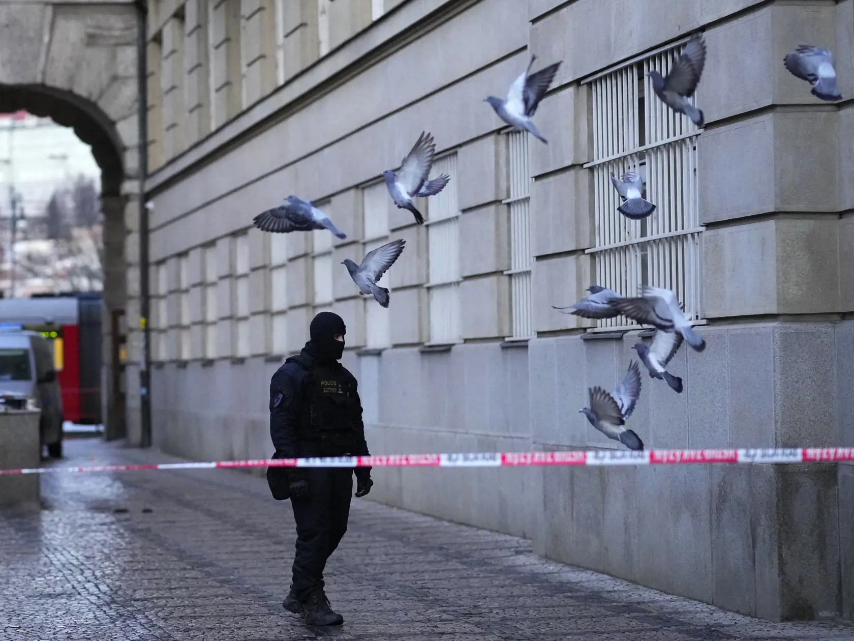 Policajt hliadkuje pred budovou Filozofickej fakulty Univerzity Karlovej (FF UK) po streľbe v centre Prahy 22. decembra 2023. Pri streľbe na Filozofickej fakulte Univerzity Karlovej v Prahe prišlo vo štvrtok o život 14 ľudí a 25 je zranených.