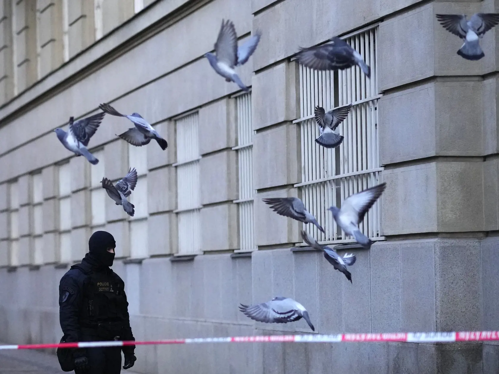 Policajt hliadkuje pred budovou Filozofickej fakulty Univerzity Karlovej (FF UK) po streľbe v centre Prahy 22. decembra 2023. Pri streľbe na Filozofickej fakulte Univerzity Karlovej v Prahe prišlo vo štvrtok o život 14 ľudí a 25 je zranených. Strelec bol podľa polície študentom školy a po útoku zrejme spáchal samovraždu, no strieľali po ňom aj policajti.
