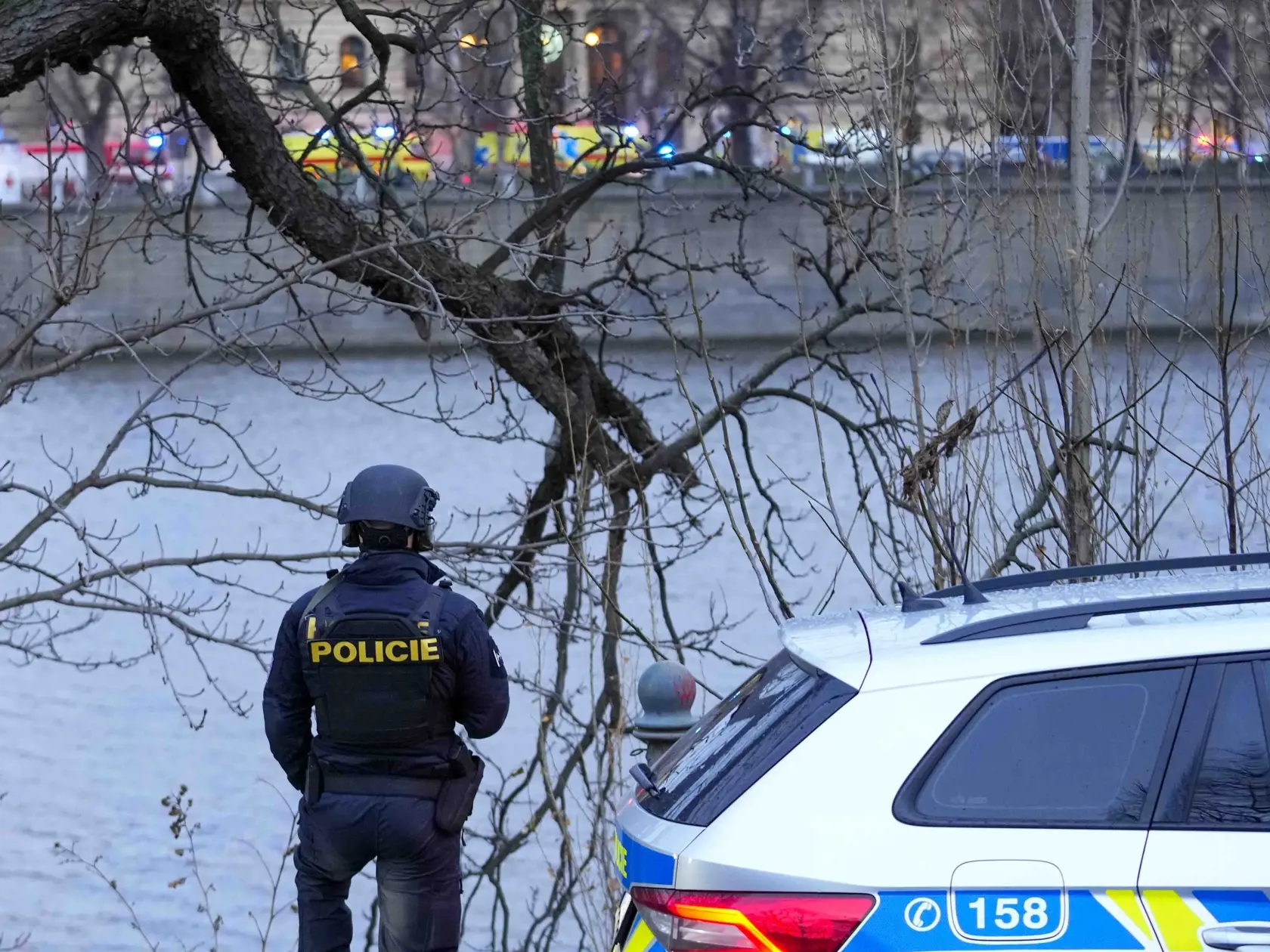 Policajt stojí na brehu Vltavy po streľbe v centre Prahy 21. decembra 2023. Česká polícia zneškodnila útočníka, ktorý vo štvrtok strieľal v škole v centre Prahy. Uviedla to na sociálnej sieti X. Na mieste je podľa nej niekoľko mŕtvych a desiatky zranených, informuje spravodajkyňa TASR v Prahe.