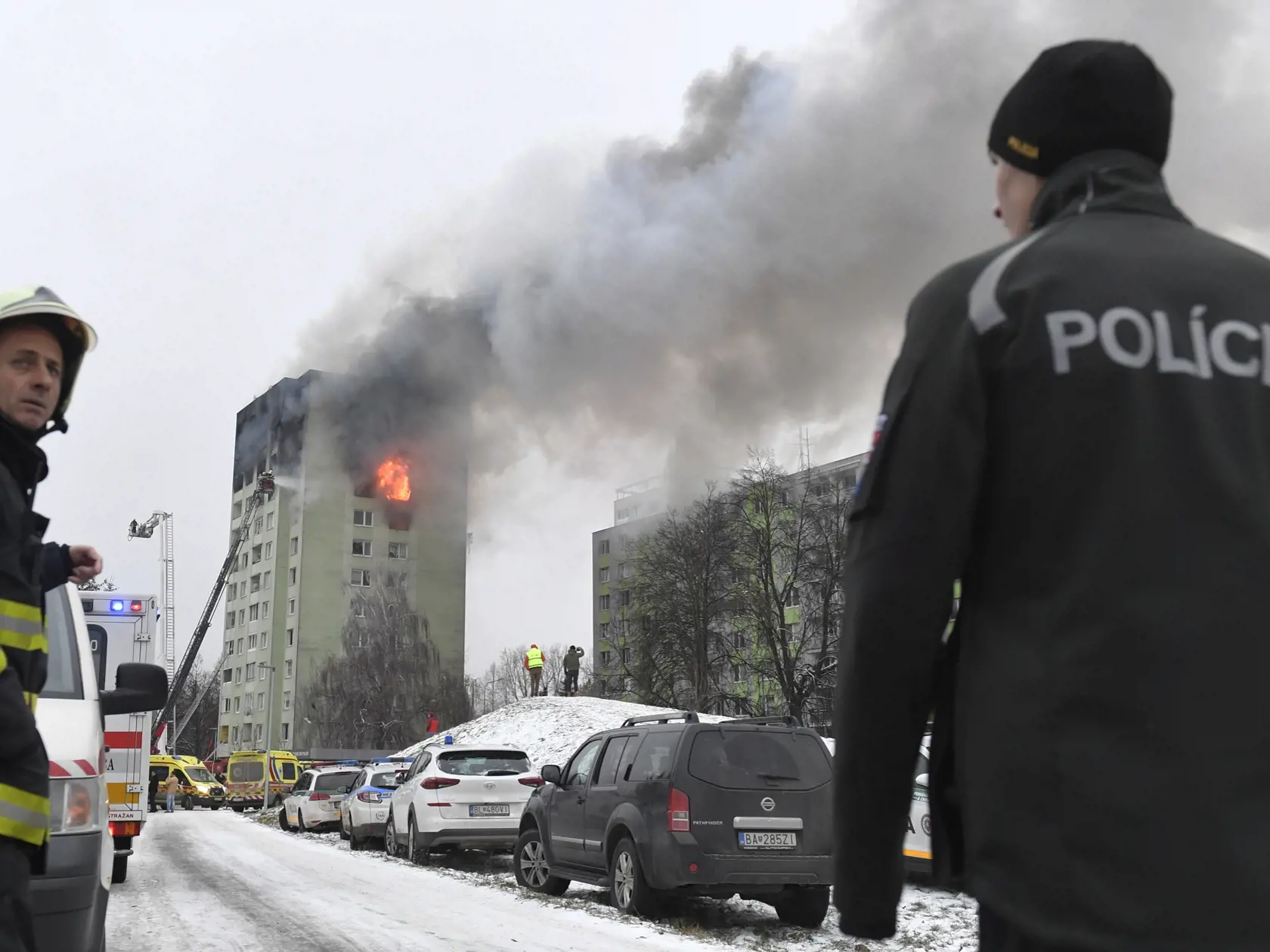 Hasič a policajt počas zásahu na mieste výbuchu a požiari bytového domu 6. decembra 2019 v Prešove. Požiar nal vzniknúť po výbuchu horných poschodí 12 pododlažnej bytovky pred 12.15 h. Polícia zatiaľ potvrdila štyri obete.  FOTO TASR - František Iván 