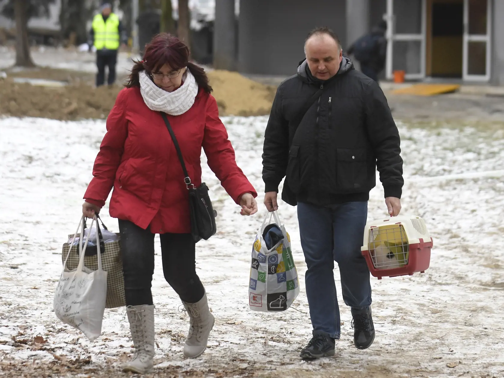 Na snímke ľudia si odnášajú veci z vedľajších bytových domov pri zhorenom bytovom dome v Prešove 7. decembra 2019. Požiar mal vzniknúť po výbuchu horných poschodí 12-podlažnej bytovky v piatok pred 12.15 h. FOTO TASR - František Iván